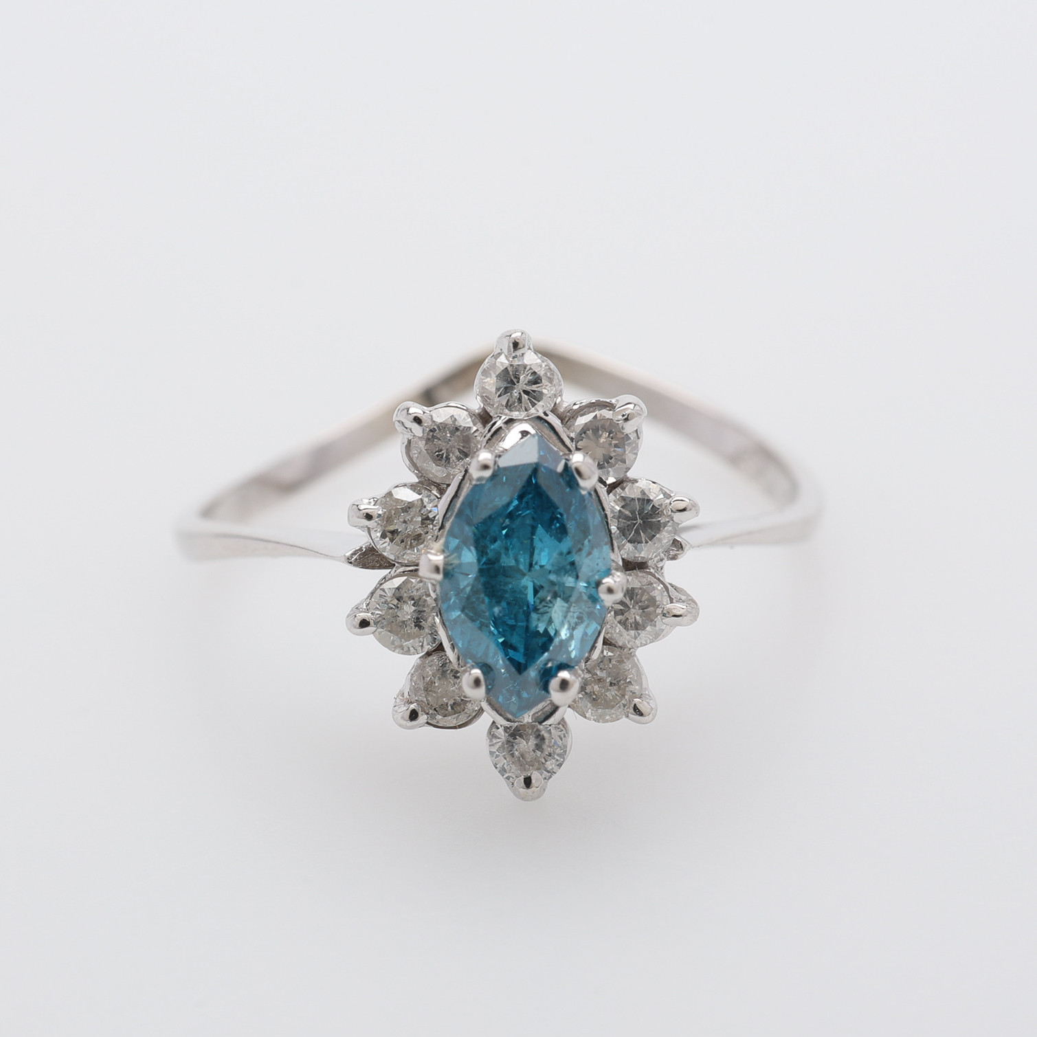 RING, 14K VITGULD, 10 ST VITA DIAMANTER & 1 NAVETTSLIPAD BEHANDLAD BLÅ DIAMANT.