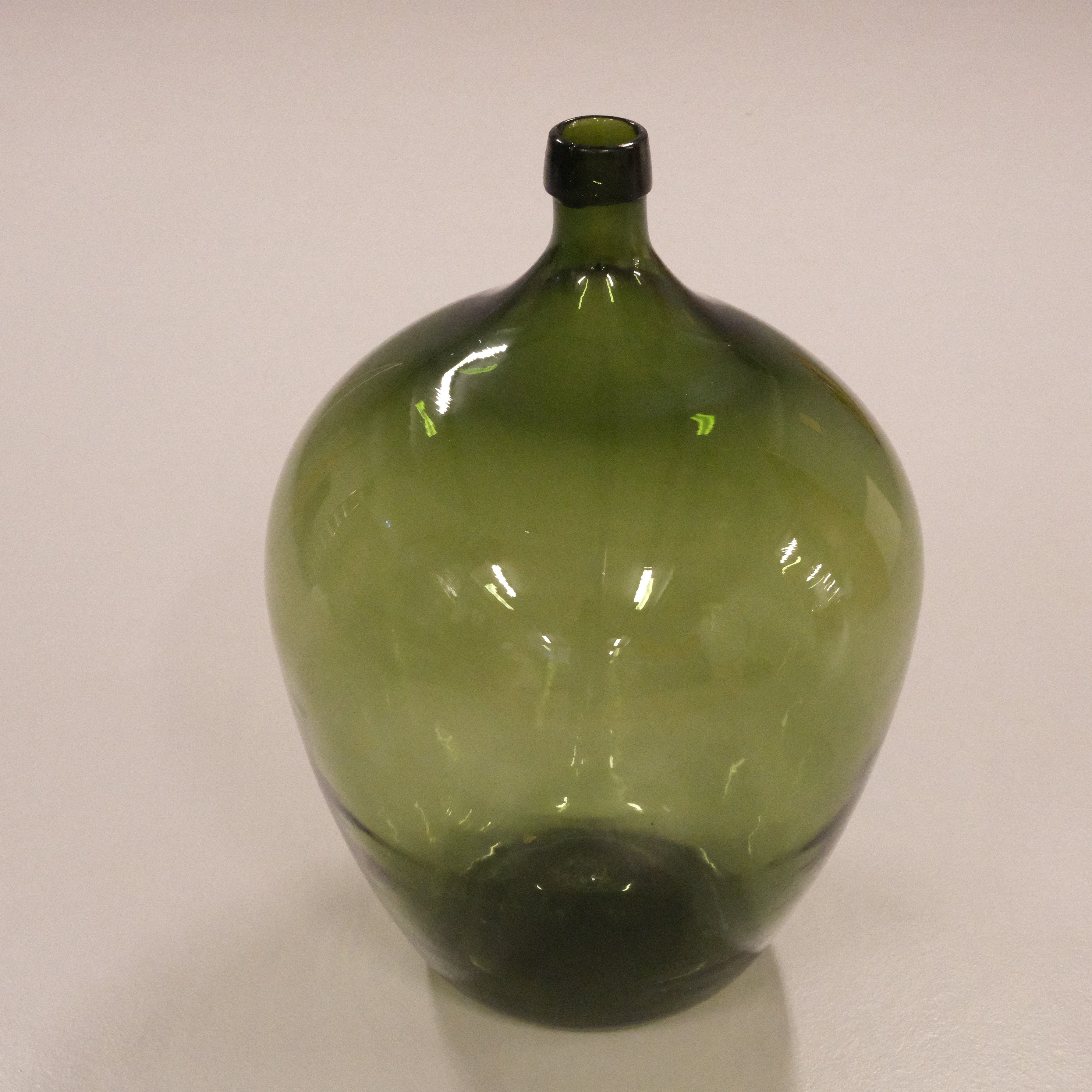 GLASFLASKA S.K. DAMEJEANNE. GRÖNT GLAS. 1900-TAL.