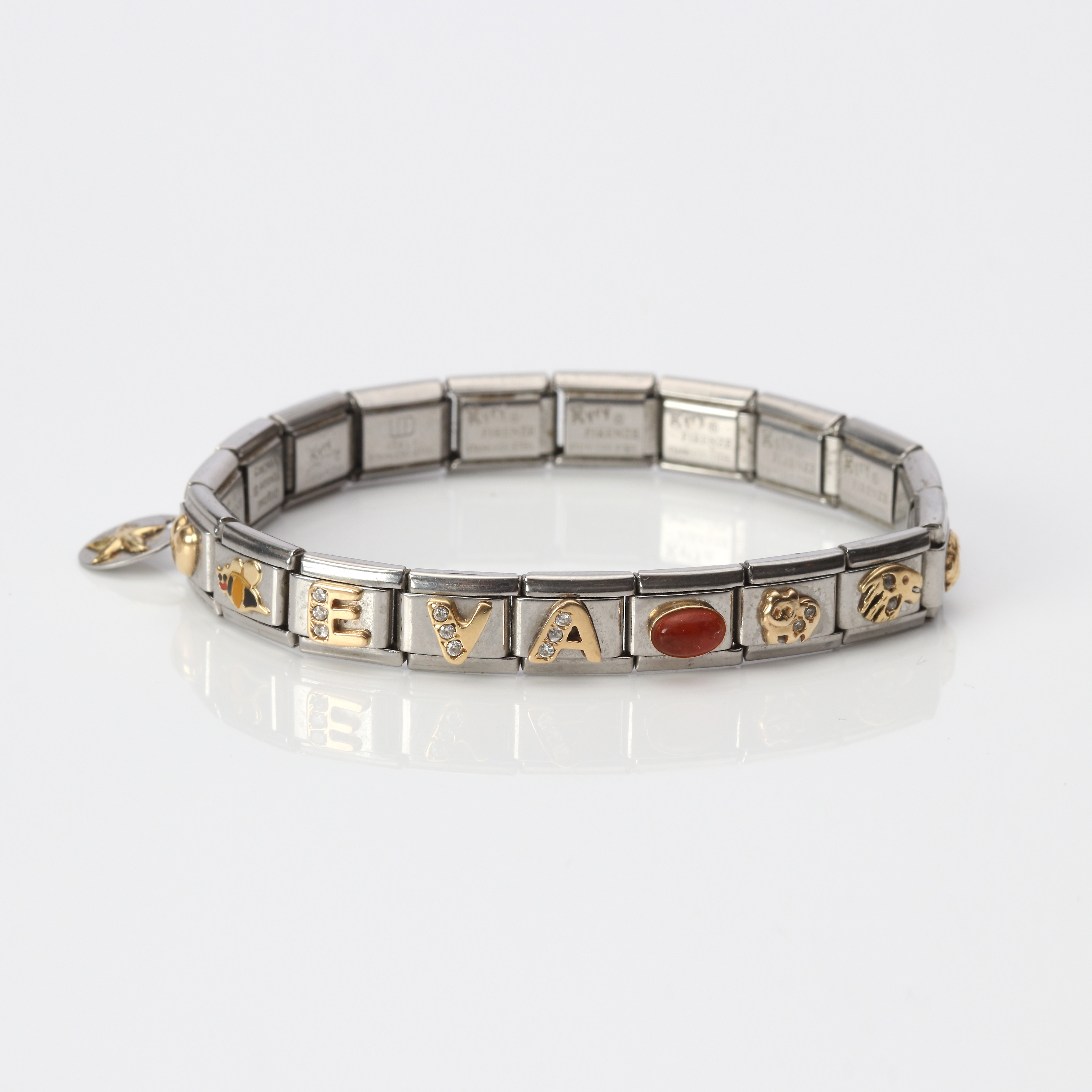 ARMBAND. Stål och guld med färglösa stenar.