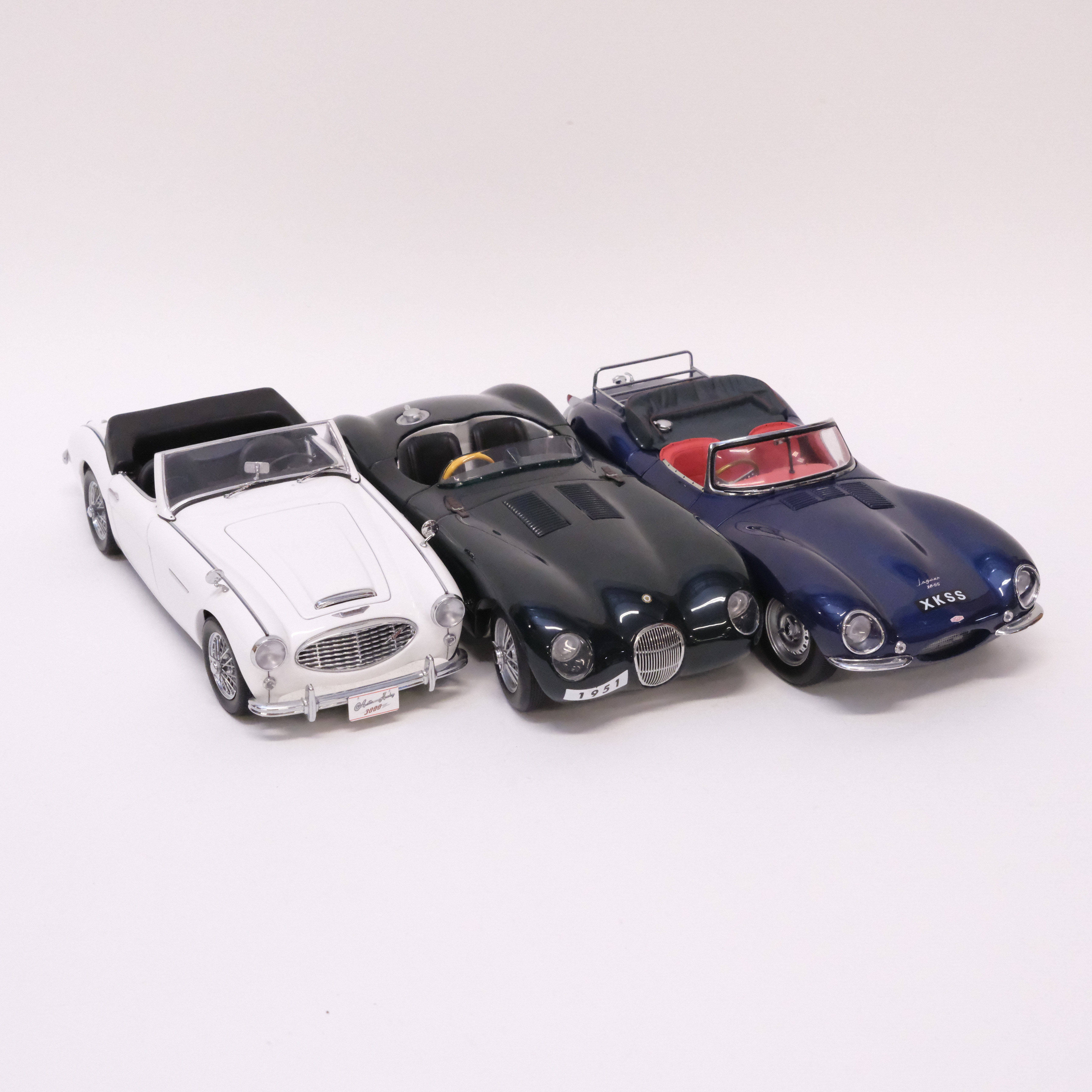 AUTOART. TRE MODELLBILAR. AUSTIN HEALEY OCH JAGUAR. SKALA 1:18.