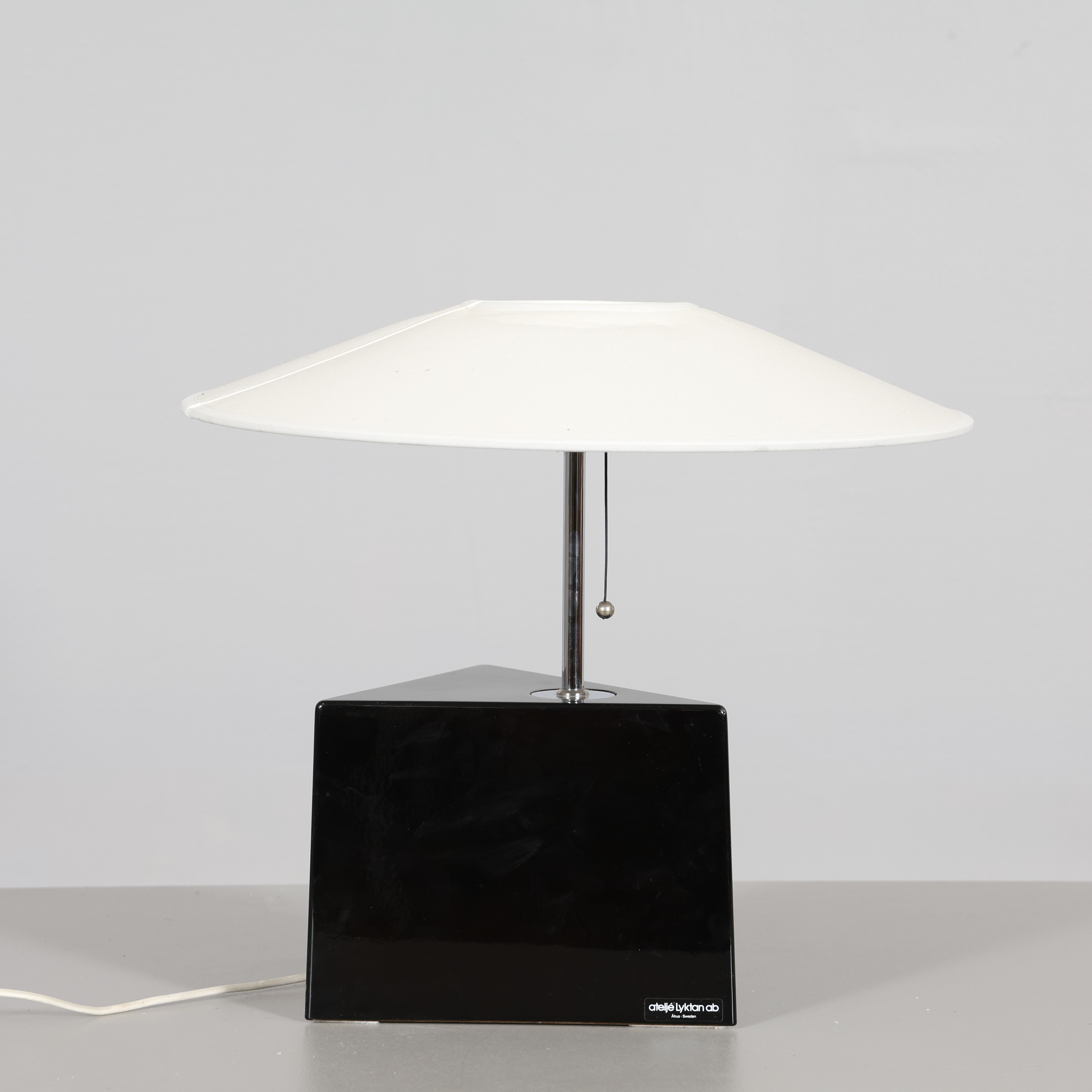 LARS BESSFELT. Bordslampa, "Triggy", Ateljé Lyktan, trekantig lampfot i svartlackerat komposit, förkromat skaft, 1980-tal.