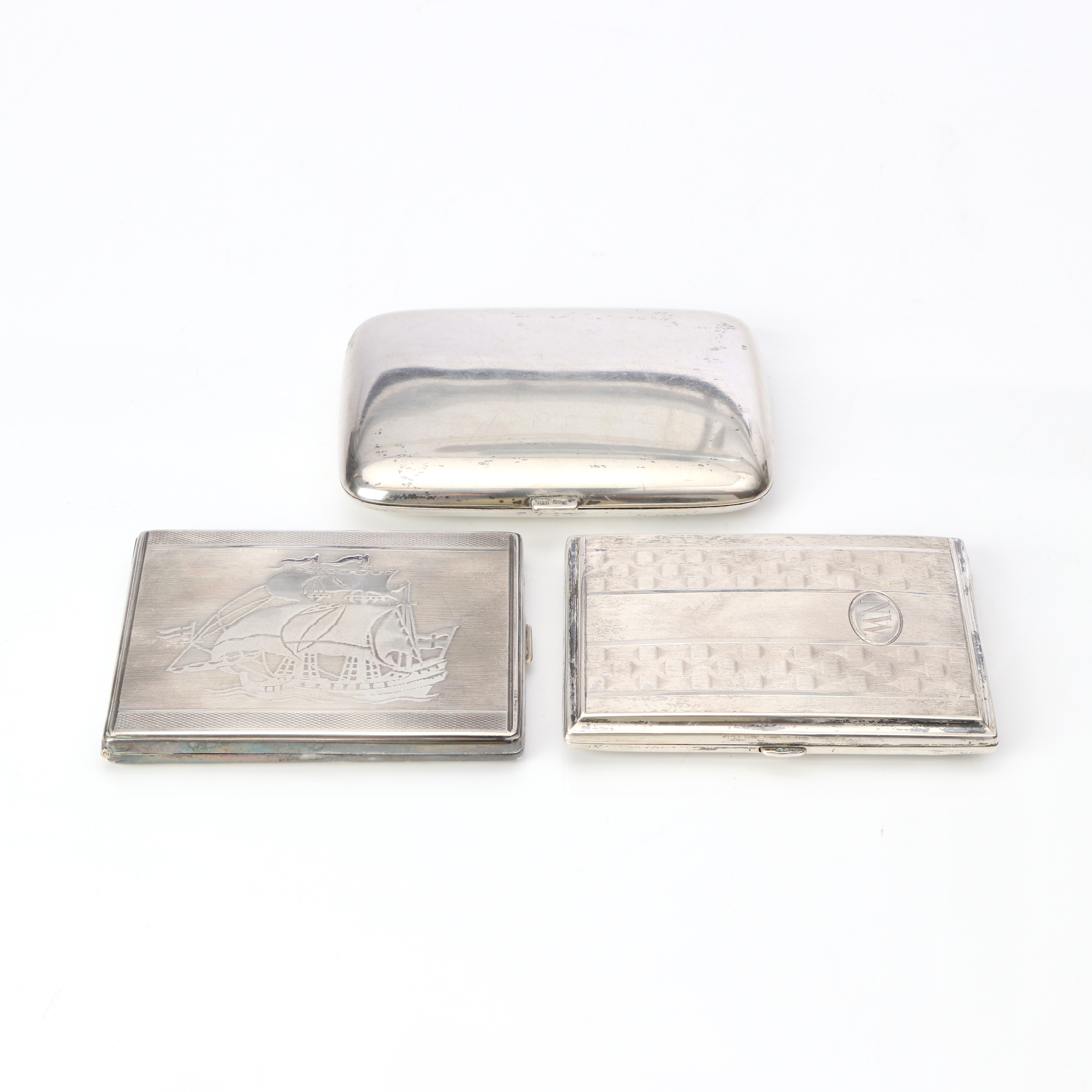 CIGARETTETUIER. Två st i silver samt ett i nysilver. Silvervikt ca 250 gram.