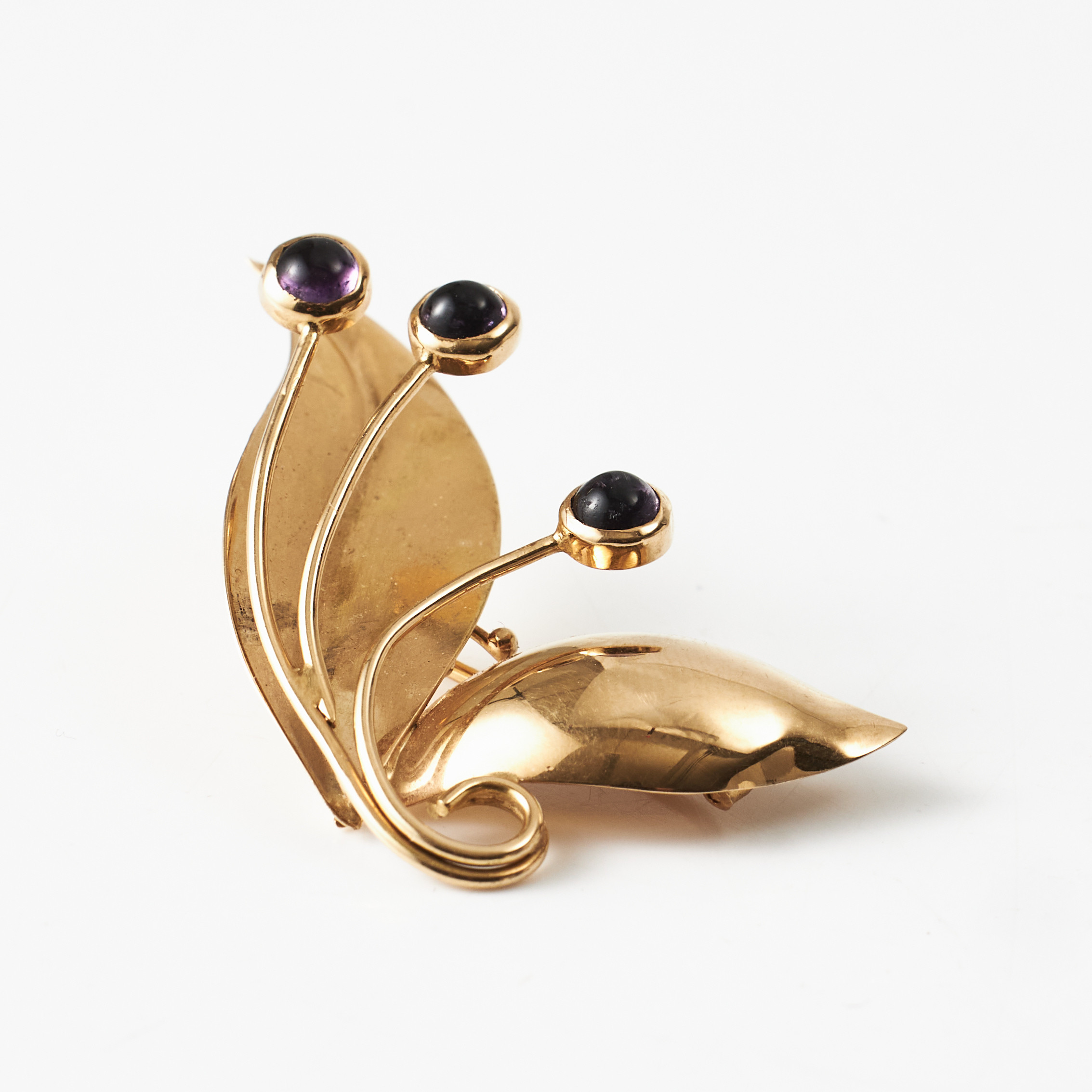 BROSCH, 18 k guld, 2 blad med dekor av 3 cabochonslipade ametister, Stockholm 1953.