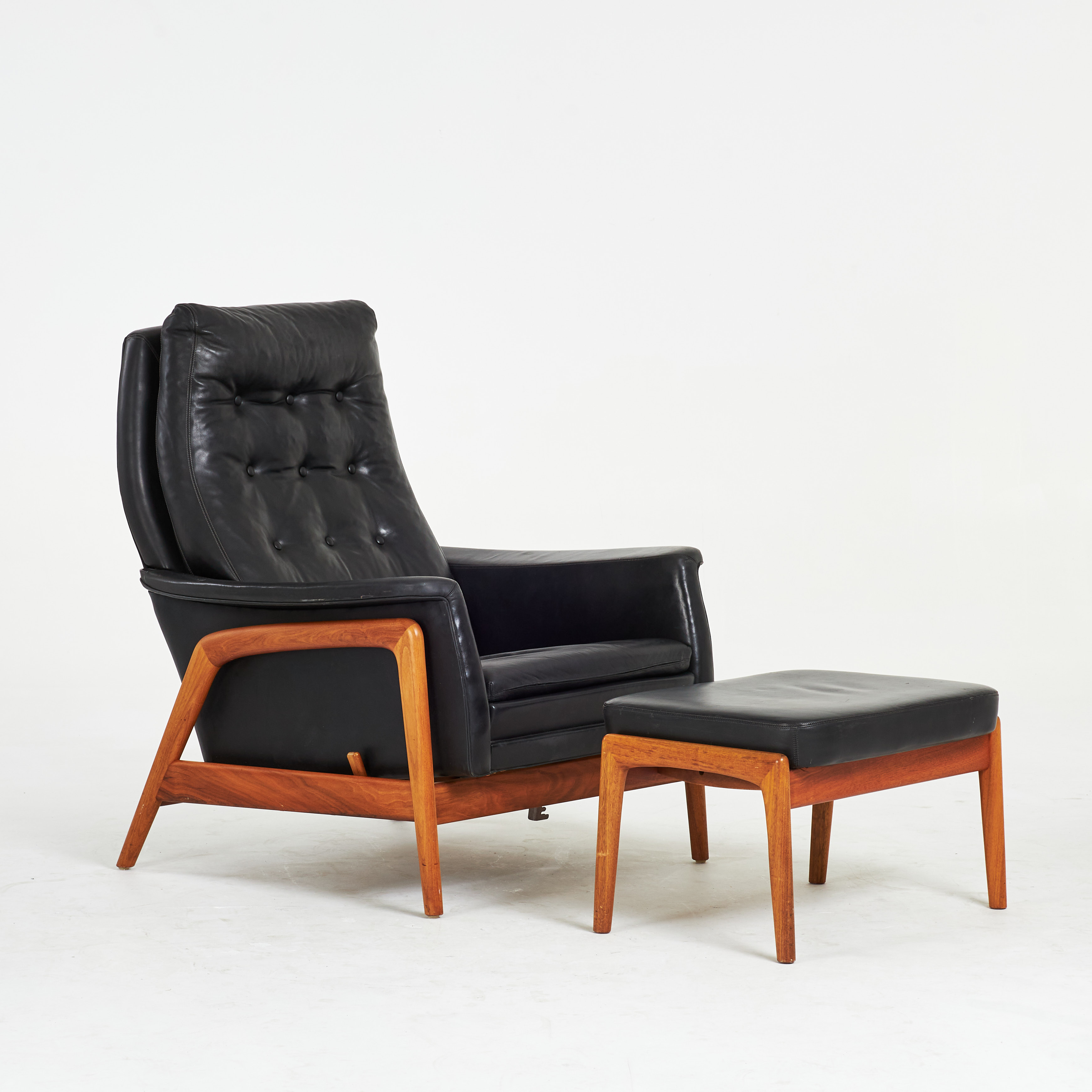 FOLKE OHLSSON. Fåtölj med fotpall, "Profil", Dux, 1950/60-tal, valnöt, helklädd i svart läder, gungfunktion, ställbar fotpall.