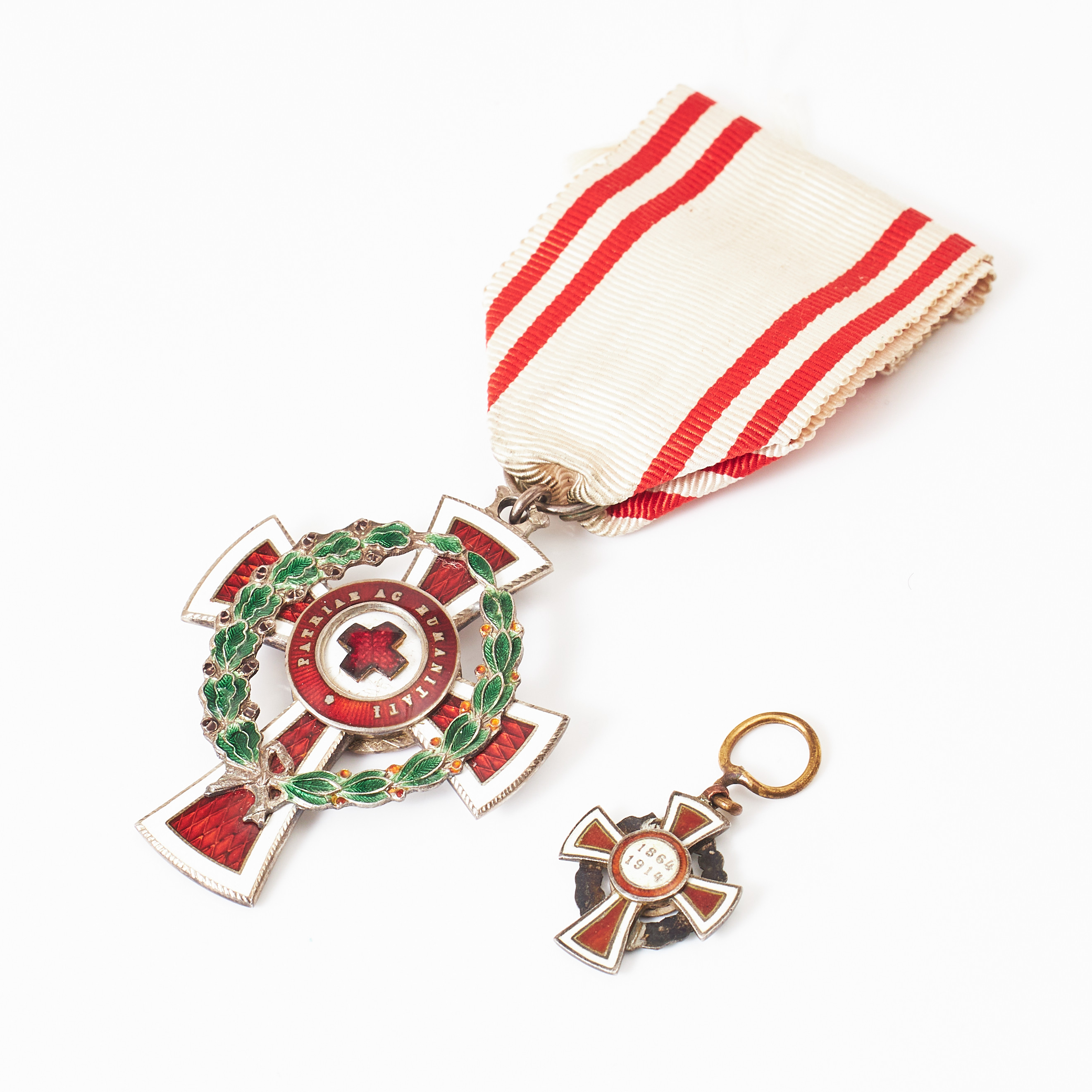 MEDALJ SAMT HEDERSTECKEN, ett i miniatyr, Röda Korset Österrike, 1864-1914, "Patriae ac humanitati", silver, vit, röd och grön emalj, dekor av lagerkrans.