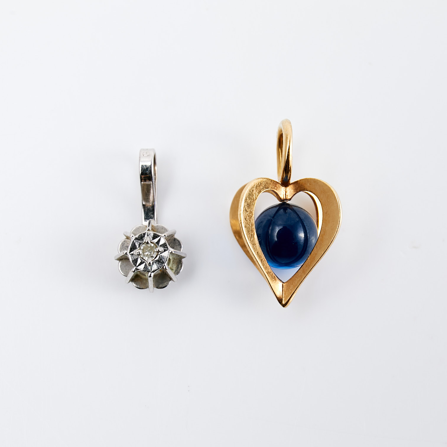 HÄNGEN, 2 st, 18 k vit- resp. rödguld, vitguld med dekor av diamant, rödguld med blått glas, svenska importstämplar resp. Olof Pettersson Ab, Stockholm, 1975.