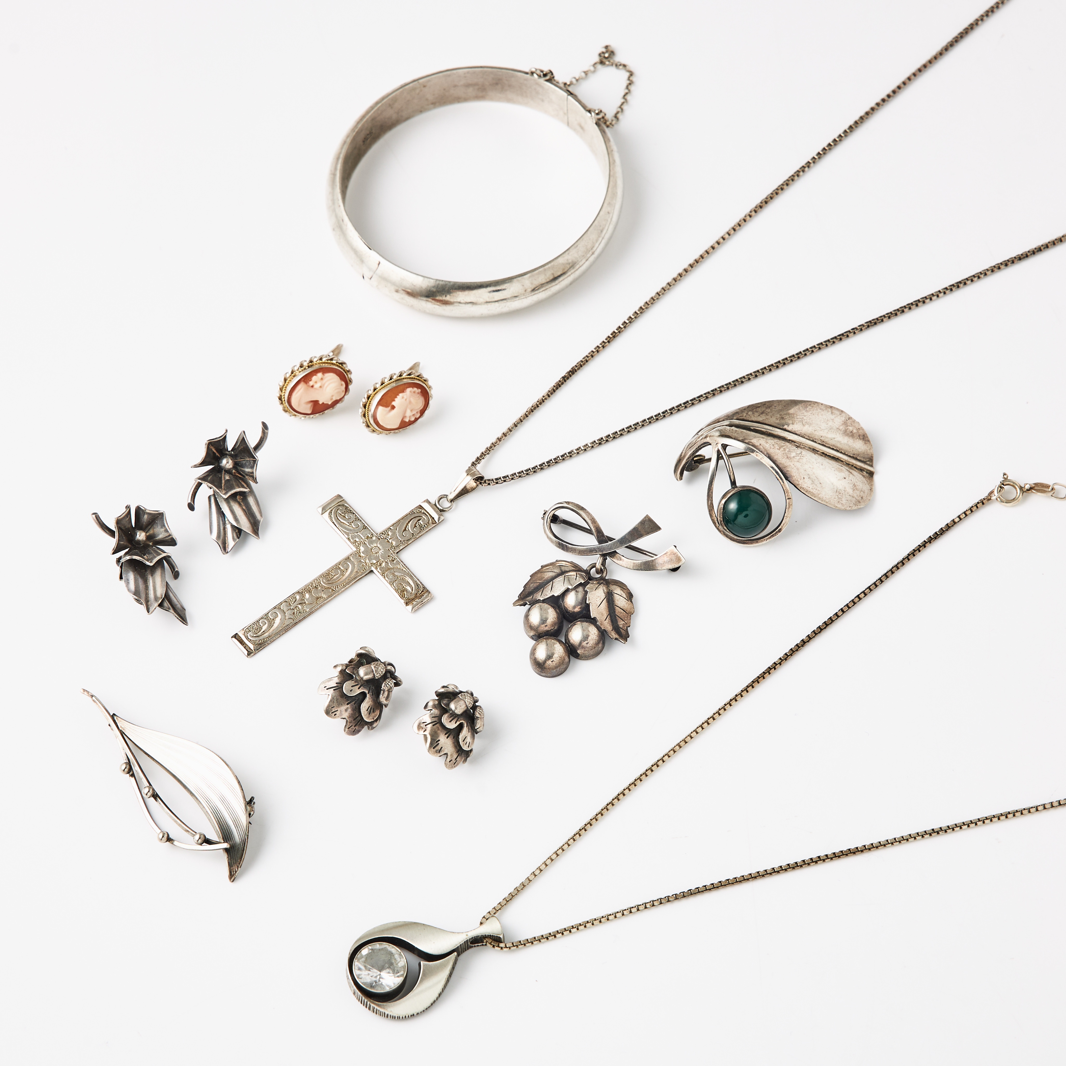 ARMRING, BROSCHER, 3 st., en i form av vindruvsklase, ÖRHÄNGEN, 1 par, med kaméer, skuret snäckskal föreställande klassiska kvinnoprofiler, CLIPS, 2 par, HÄNGEN, 2 st., kors resp. av Karl Laine, Finn Feelings, KEDJOR, 2 st., silver/sterlingsilver.