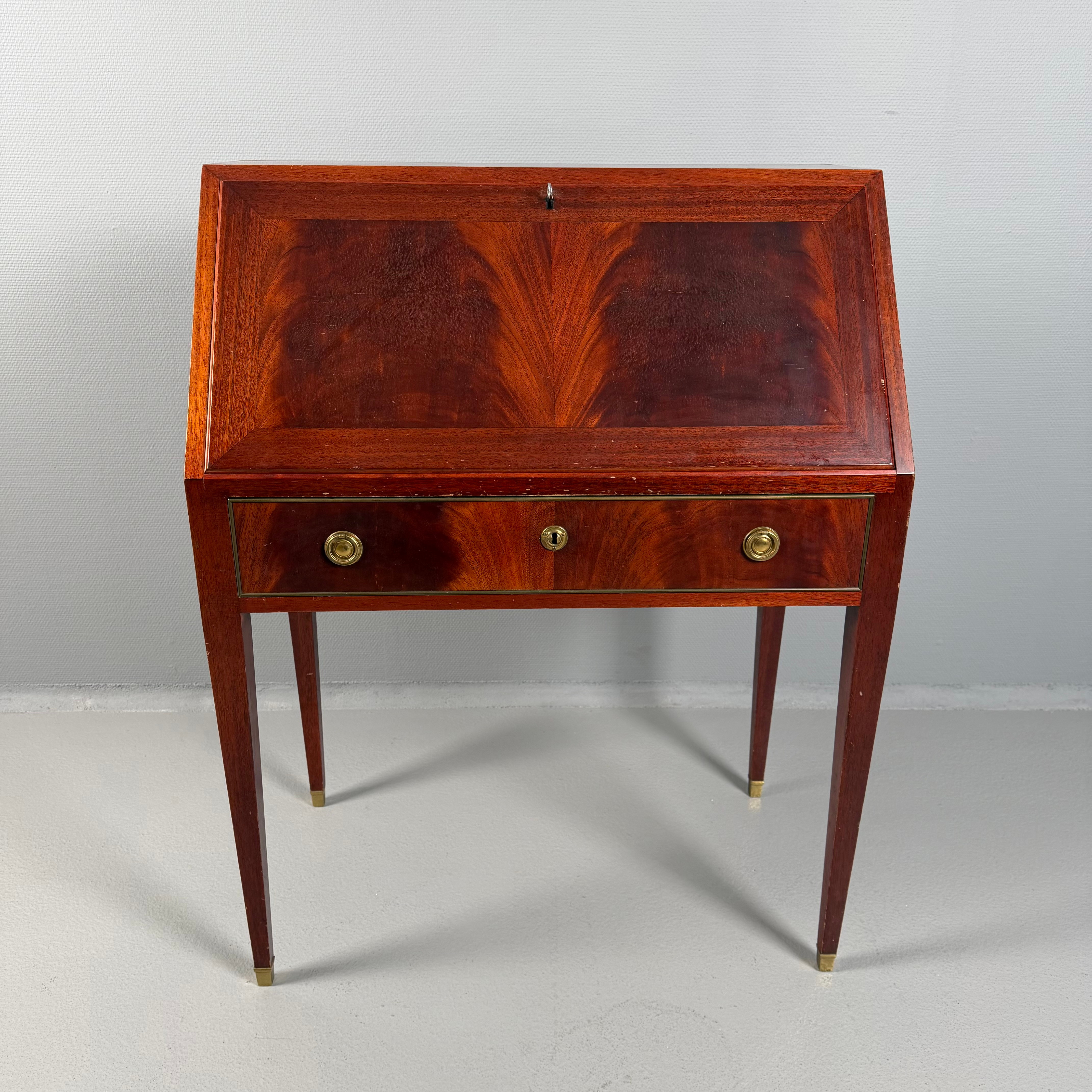 SNEDKLAFFSSEKRETÄR, 1940-tal, gustaviansk stil, fanér i mahogny, beslag i mässing, låsbar skrivklaff med bakomvarande fack- och lådinredning, låsbar låda, rakt konande ben med fothylsor.