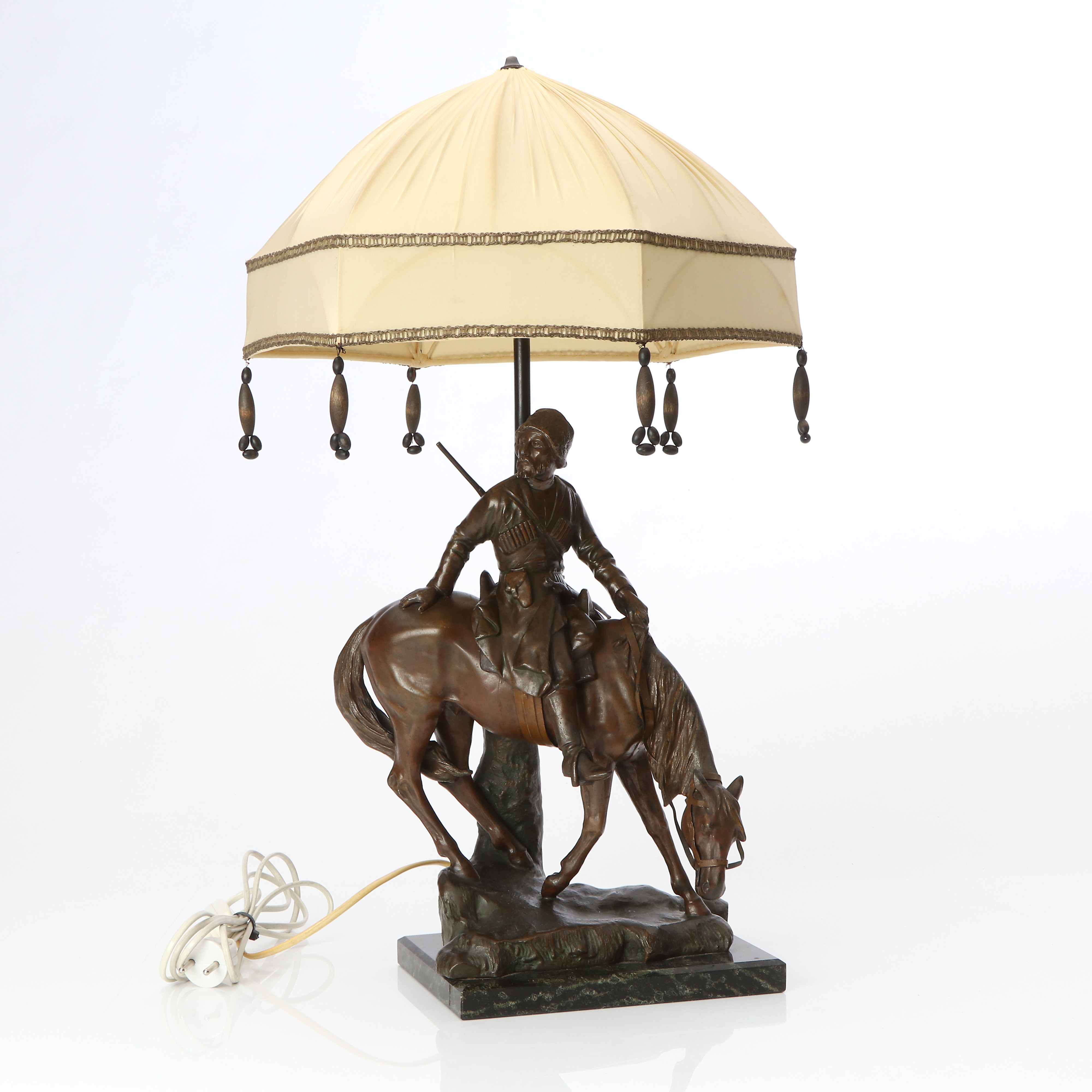 BORDSLAMPA. Bronspatinerad metall på marmorsockel. I form av kaukasisk ryttare. Tidigt 1900-tal.