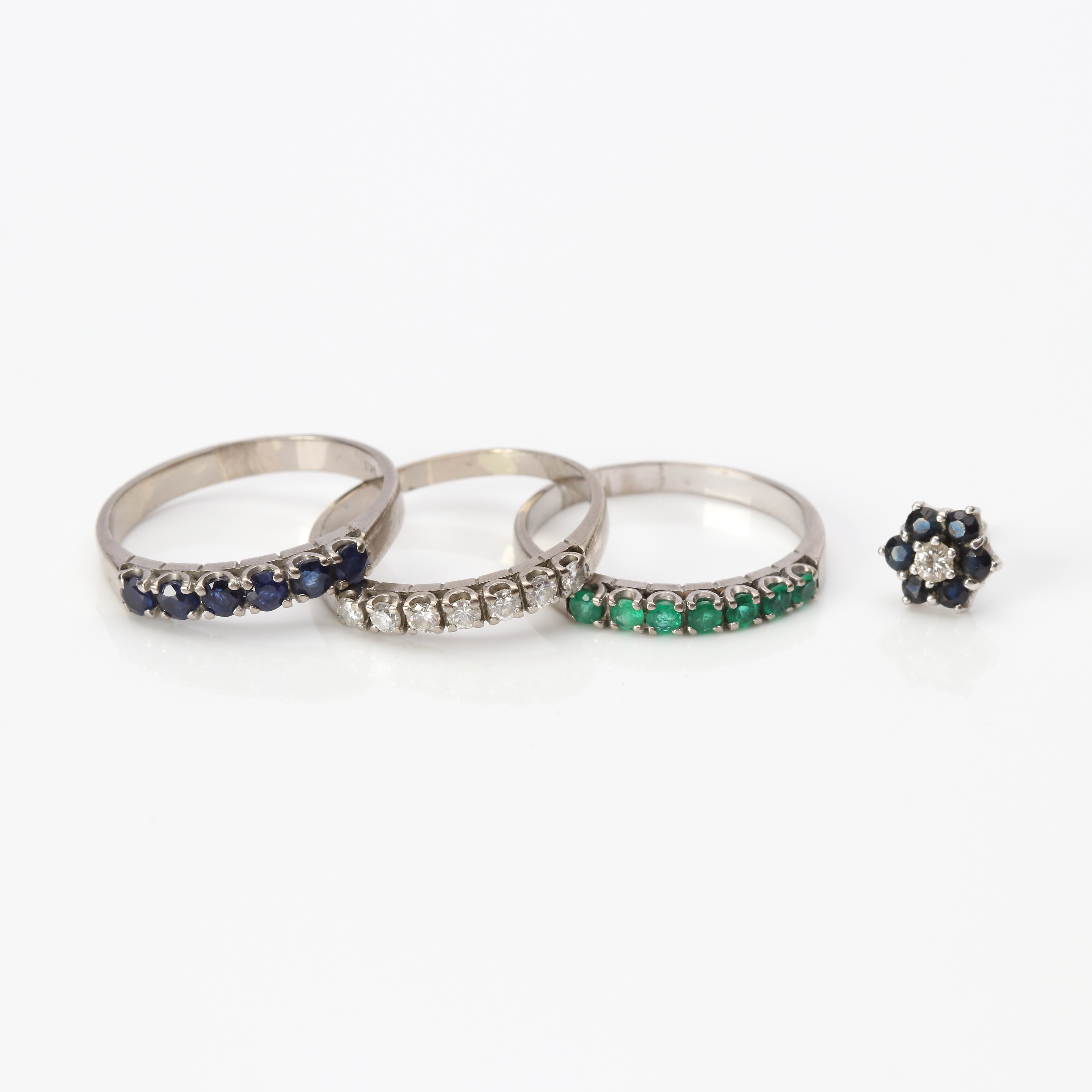 RINGAR, TRE ST OCH ETT ÖRHÄNGE. Ca 17-18k vitguld med diamanter, safirer och smaragder, totalvikt ca 8,8 gram.