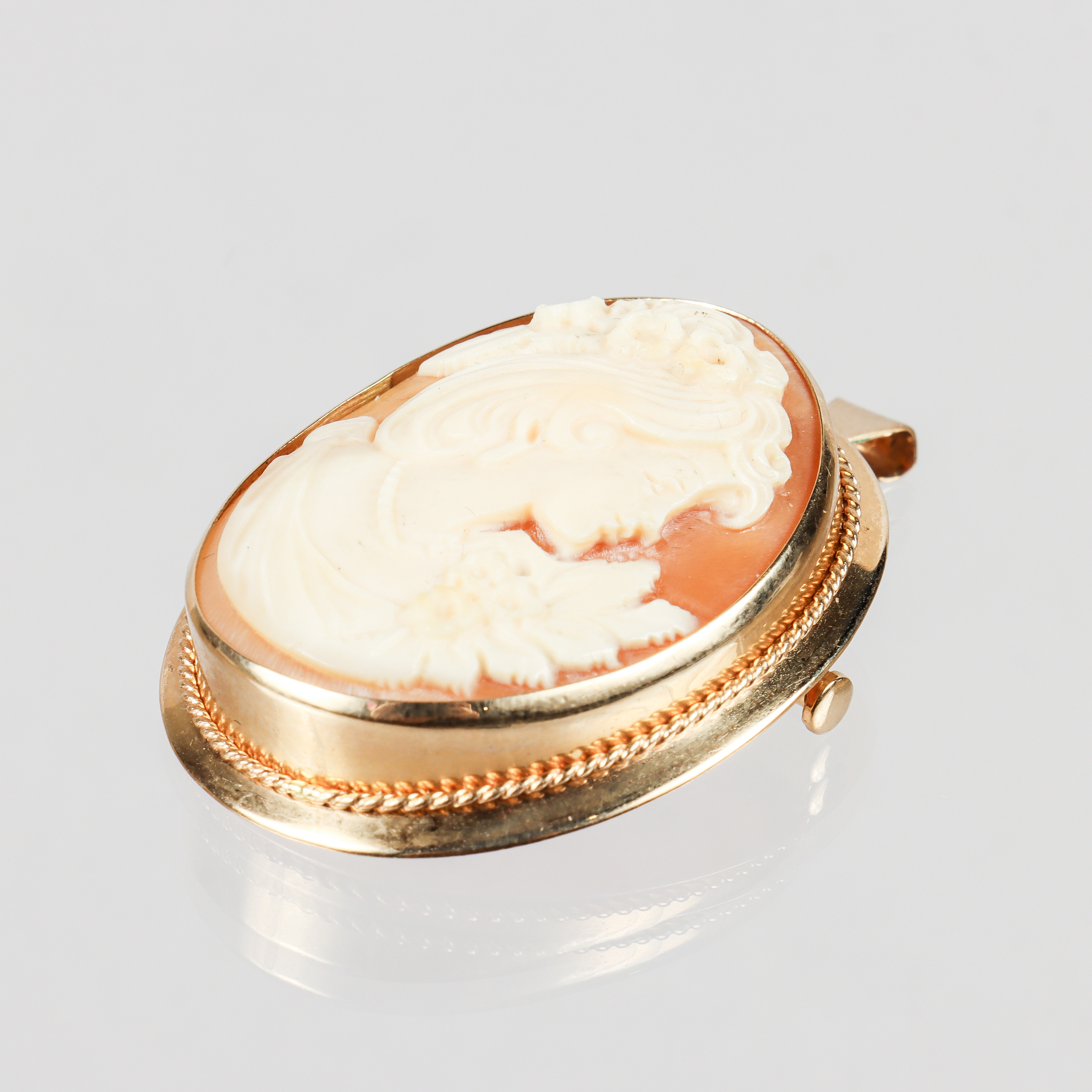 HÄNGE / BROSCH, 18K guld med skuren snäckskalskamé.