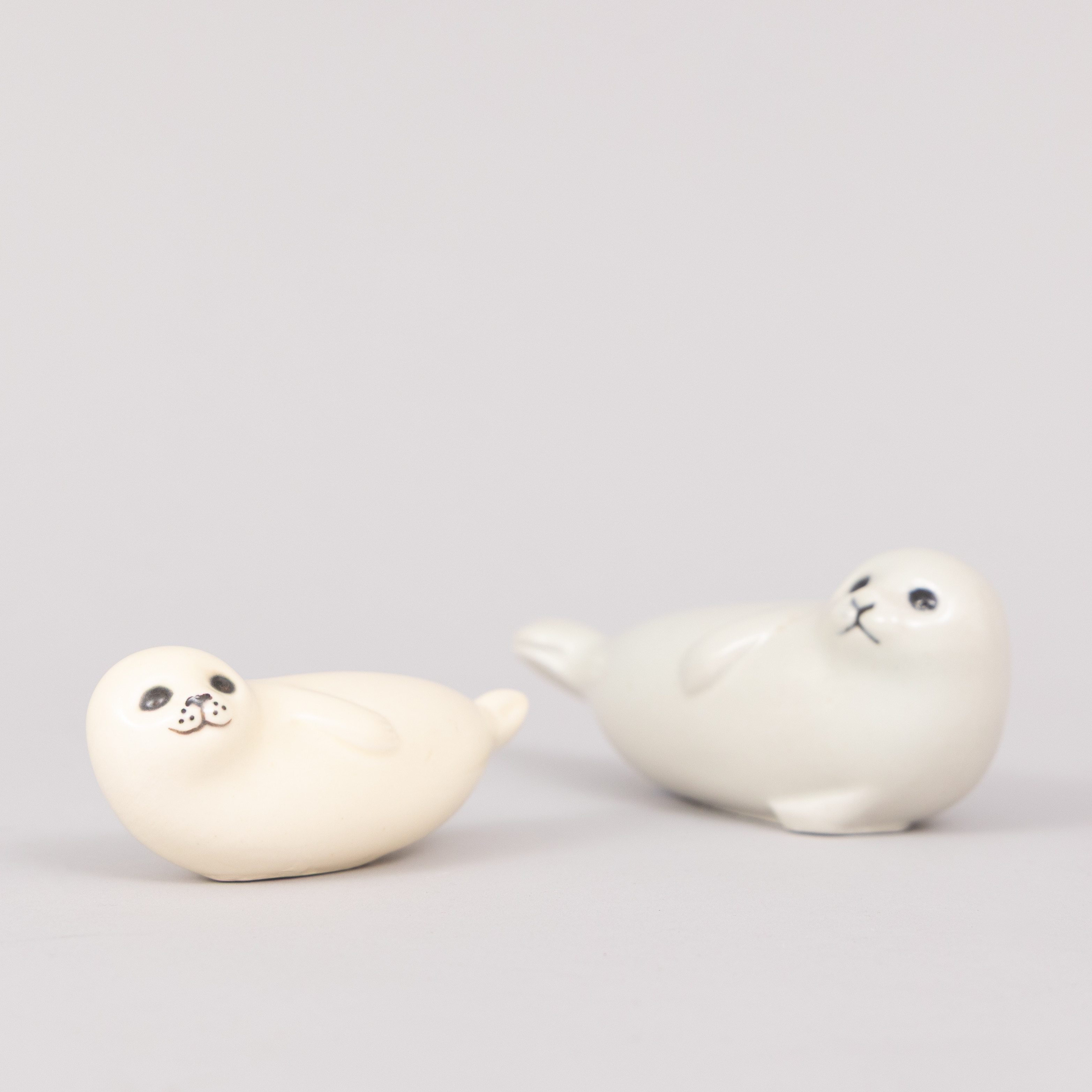 LISA LARSON. Figuriner, 2 st sälar, vitglaserat stengods, Gustavsberg, signerade.
