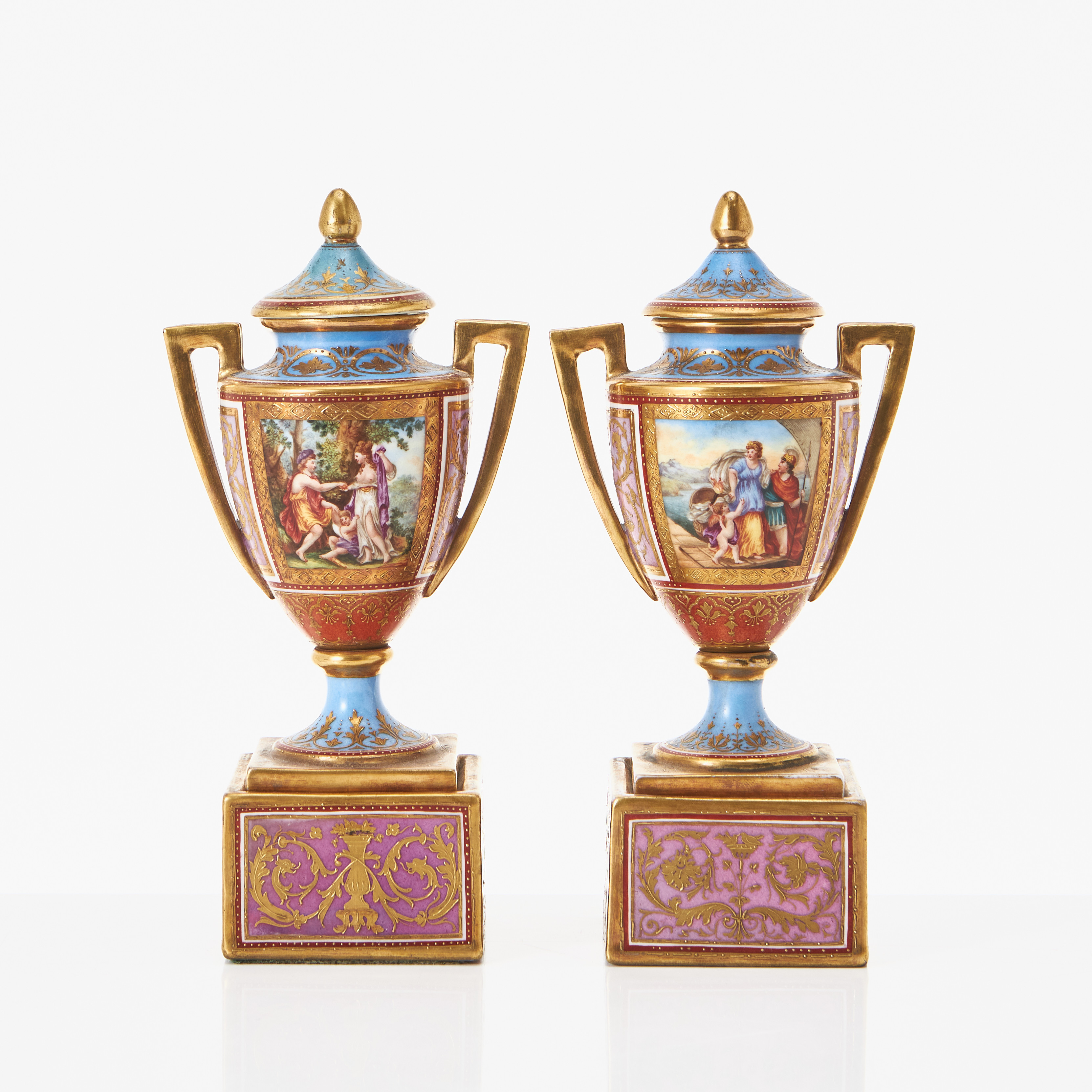 LOCKURNOR, ett par, porslin, troligen Ackermann & Fritze (etabl. 1908), Rudolstadt-Volkstedt, Tyskland, 1900-talets första kvartal, polykrom dekor, detaljer i guld, på postament.
