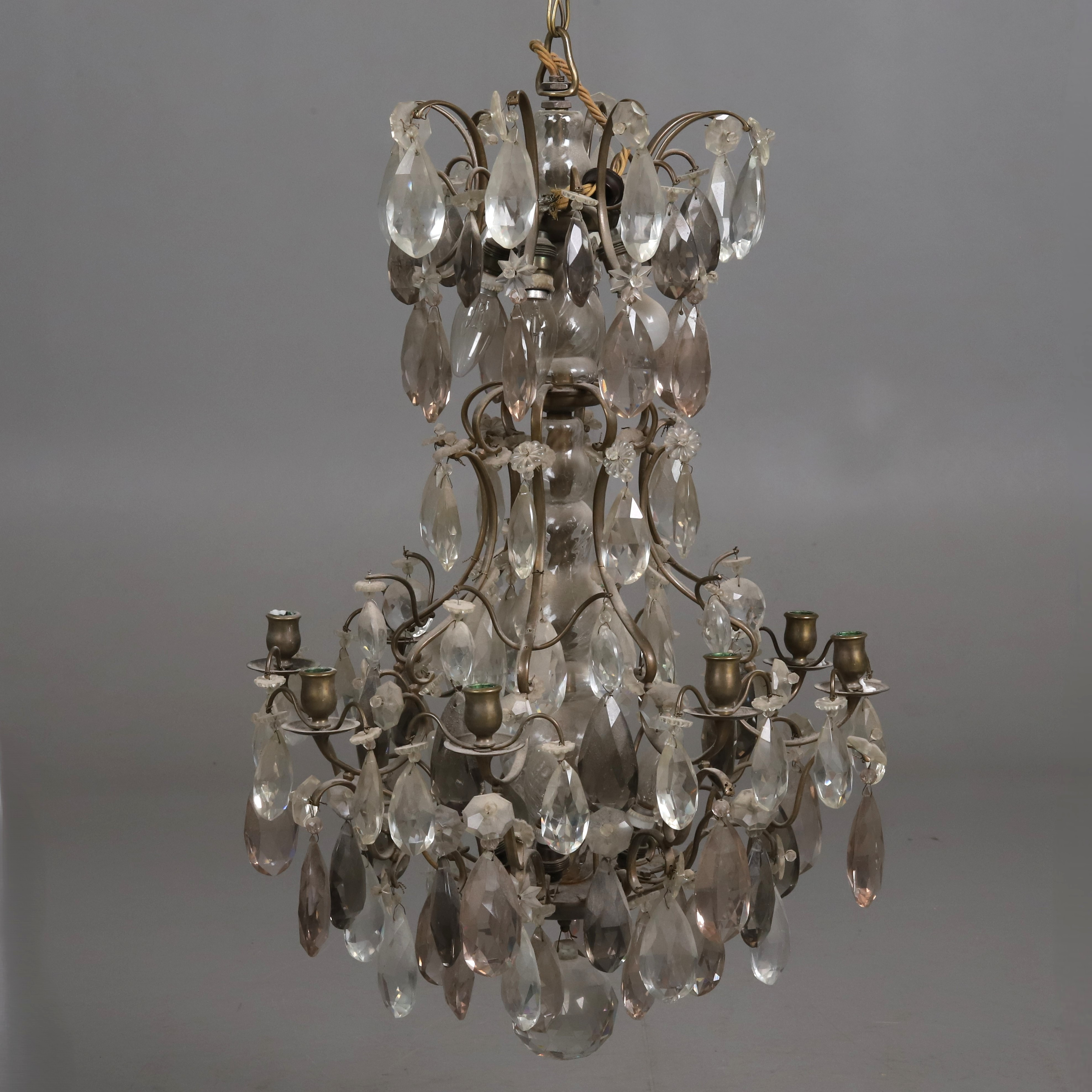 LJUSKRONA. Stomme i gulmetall med glasklädd mittpelare och prismor i klar, rosa och mörk ton. Barockstil, 18/1900-tal.