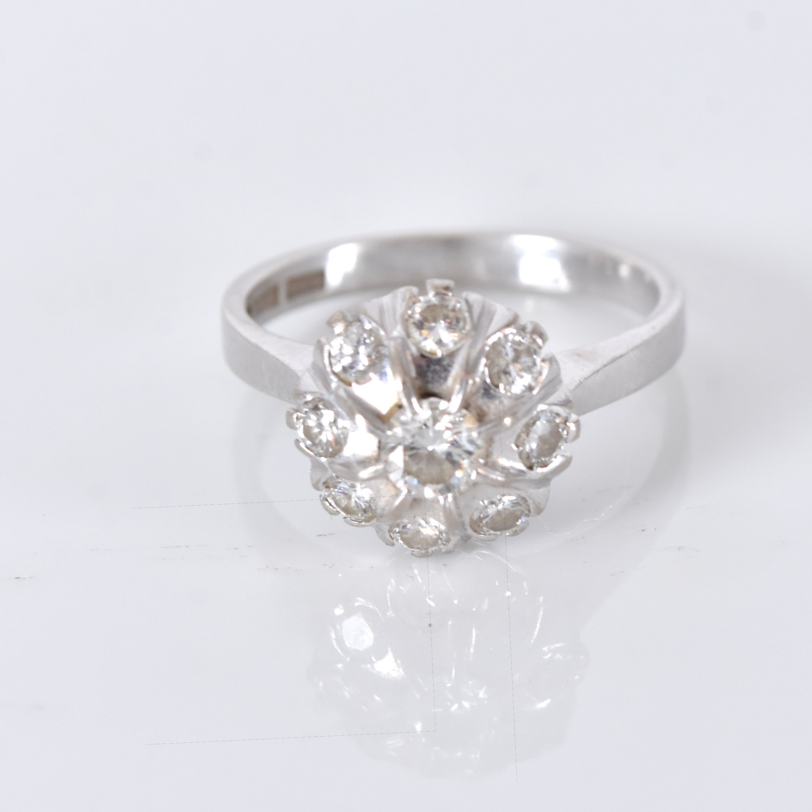 KARMOSÉRING, 18 karat vitguld med 1 + 8 briljantslipade diamanter om totalt 0,76 carat enligt gravyr.