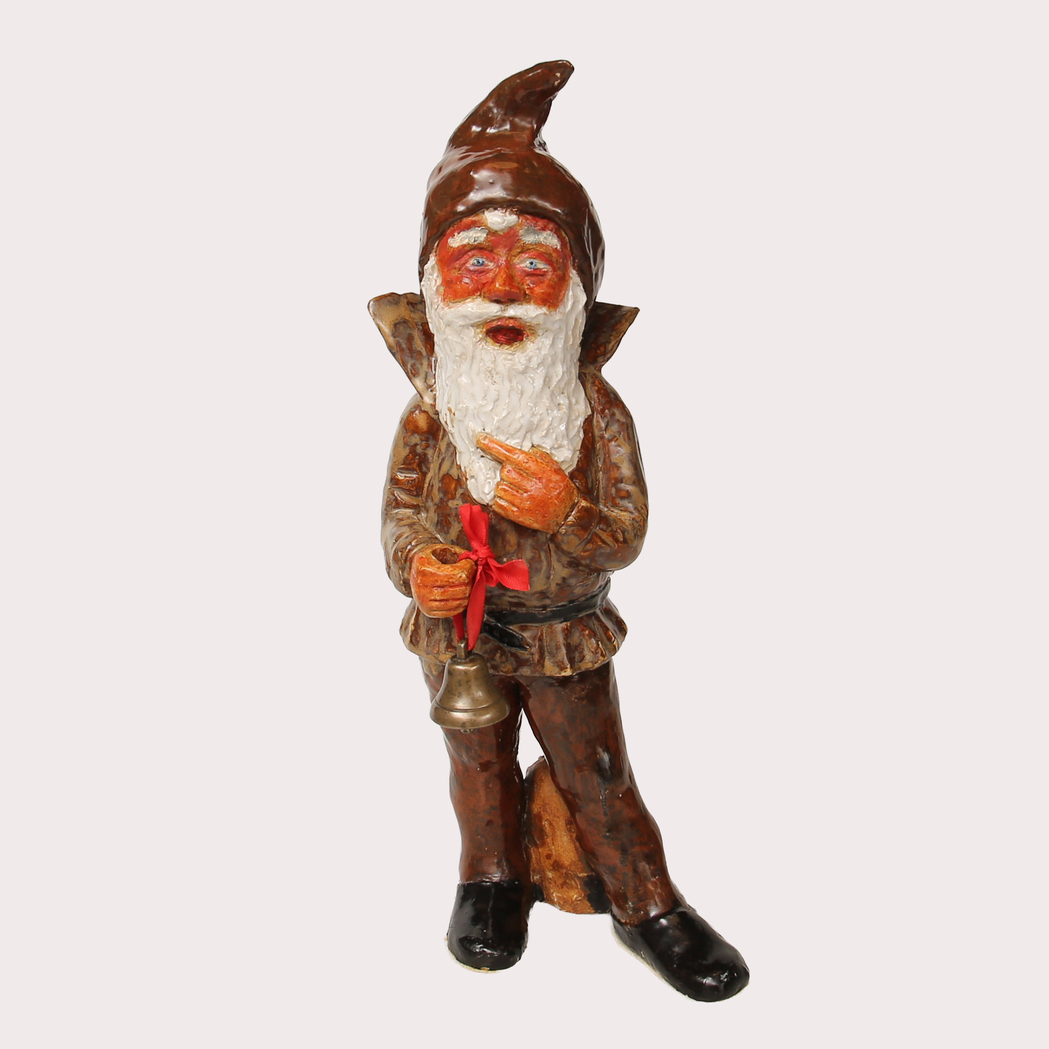 TOMTE, keramik, polykromt bemålad, med mässings klocka i ena handen. 1900-talets sista fjärdedel.
