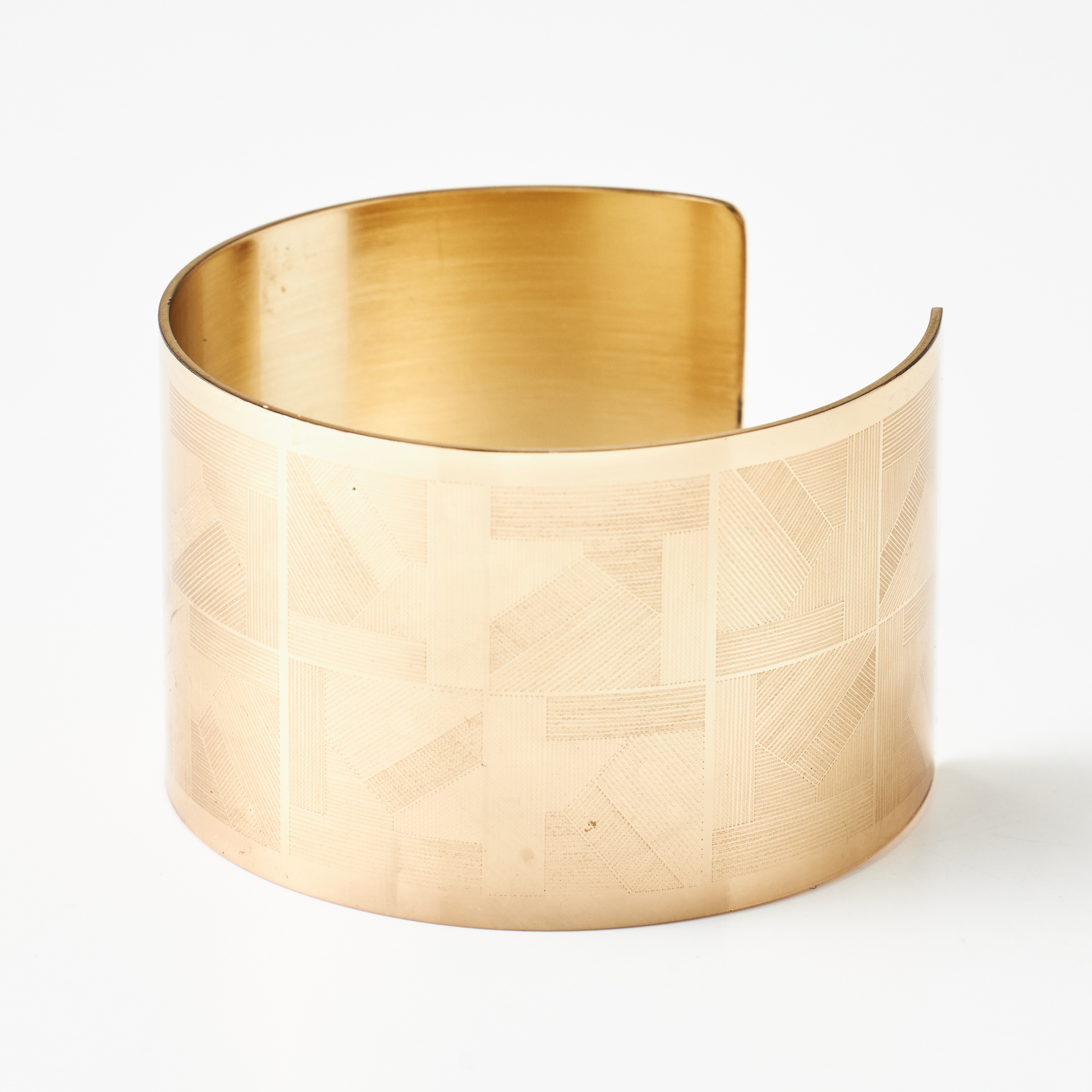 KRUG, armring, gulmetall, öppen skena, graverad geometrisk dekor, stämplad KRUG.