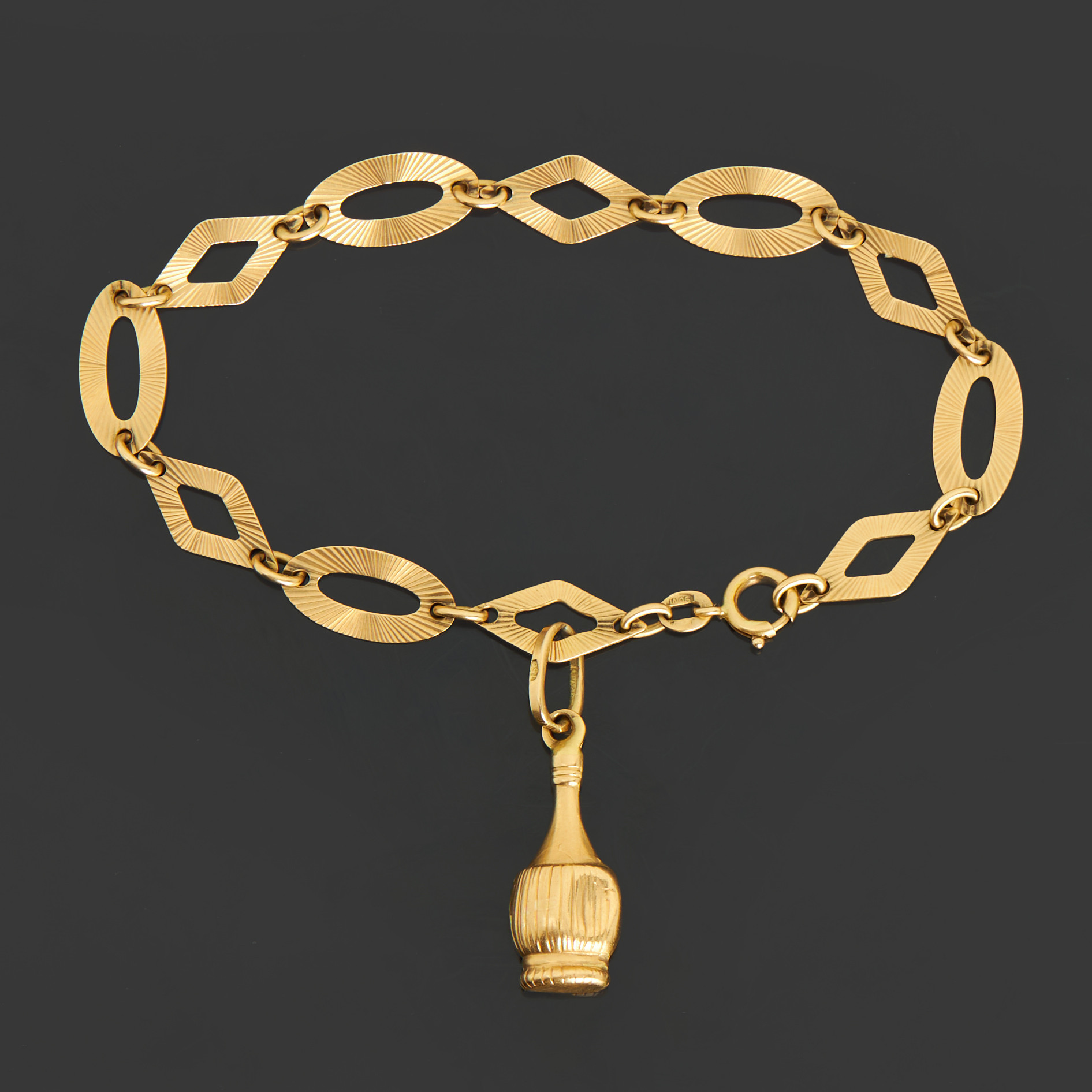 BERLOCKARMBAND, 18k guld med ovala samt rombformade länkar, berlock form av en flaska.