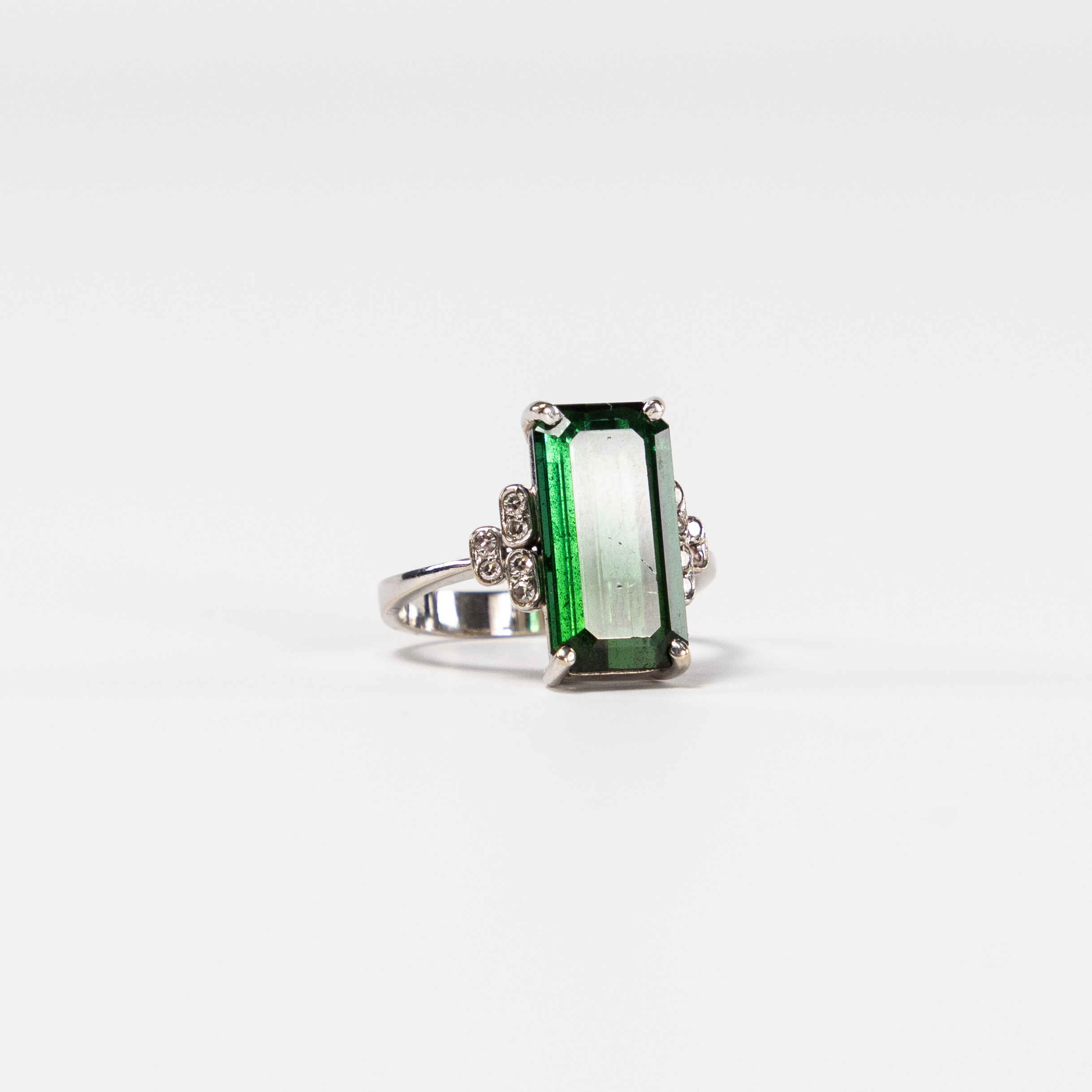 RING. 18k guld, små vita stenar, stor grön sten.