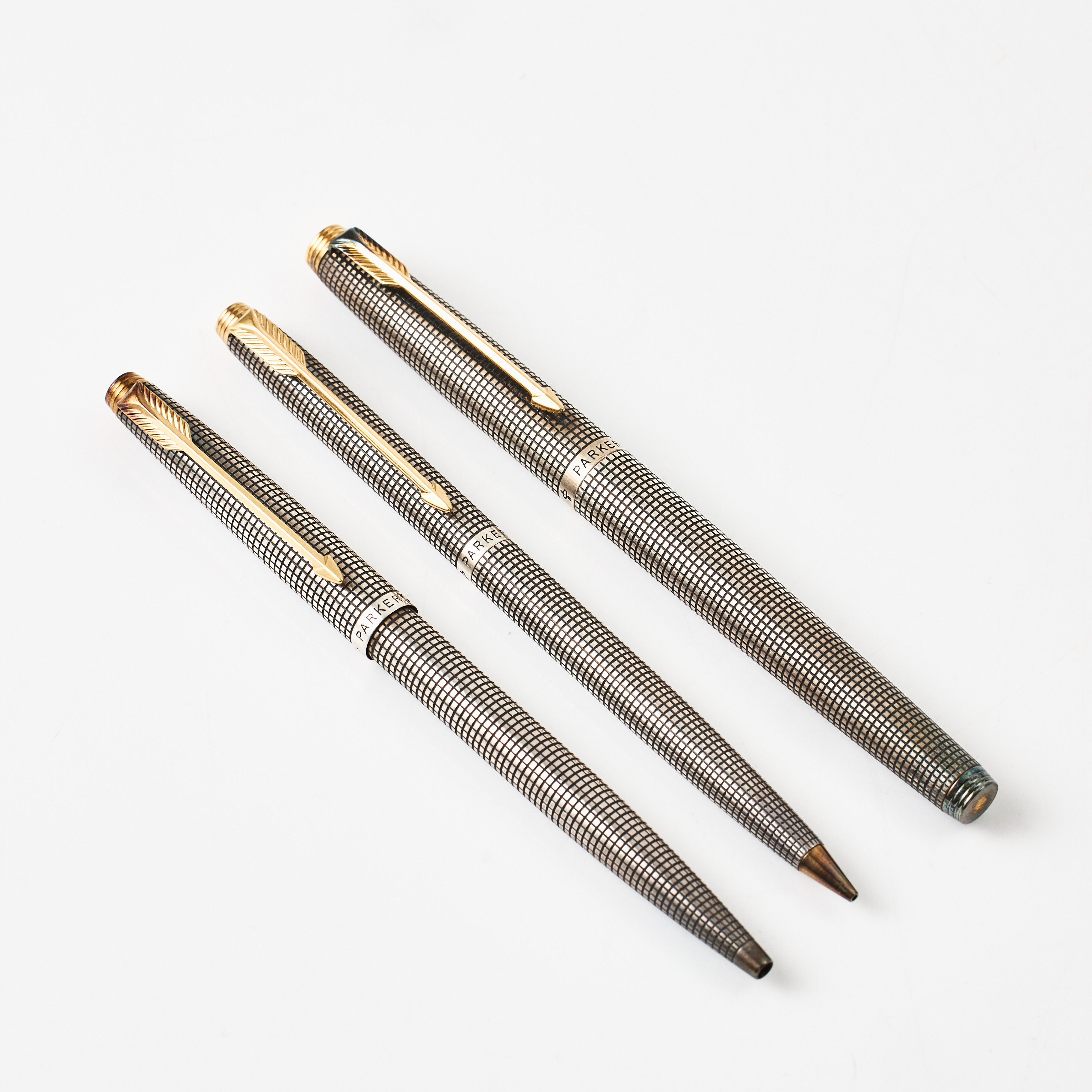 PARKER, "75", pennor, 3 st., sterlingsilver med s.k. Cross hatch mönster (rutmönster), förgyllda detaljer, bestående av: reservoarpenna med 14 k guldspets, bläckpenna, blyertspenna.