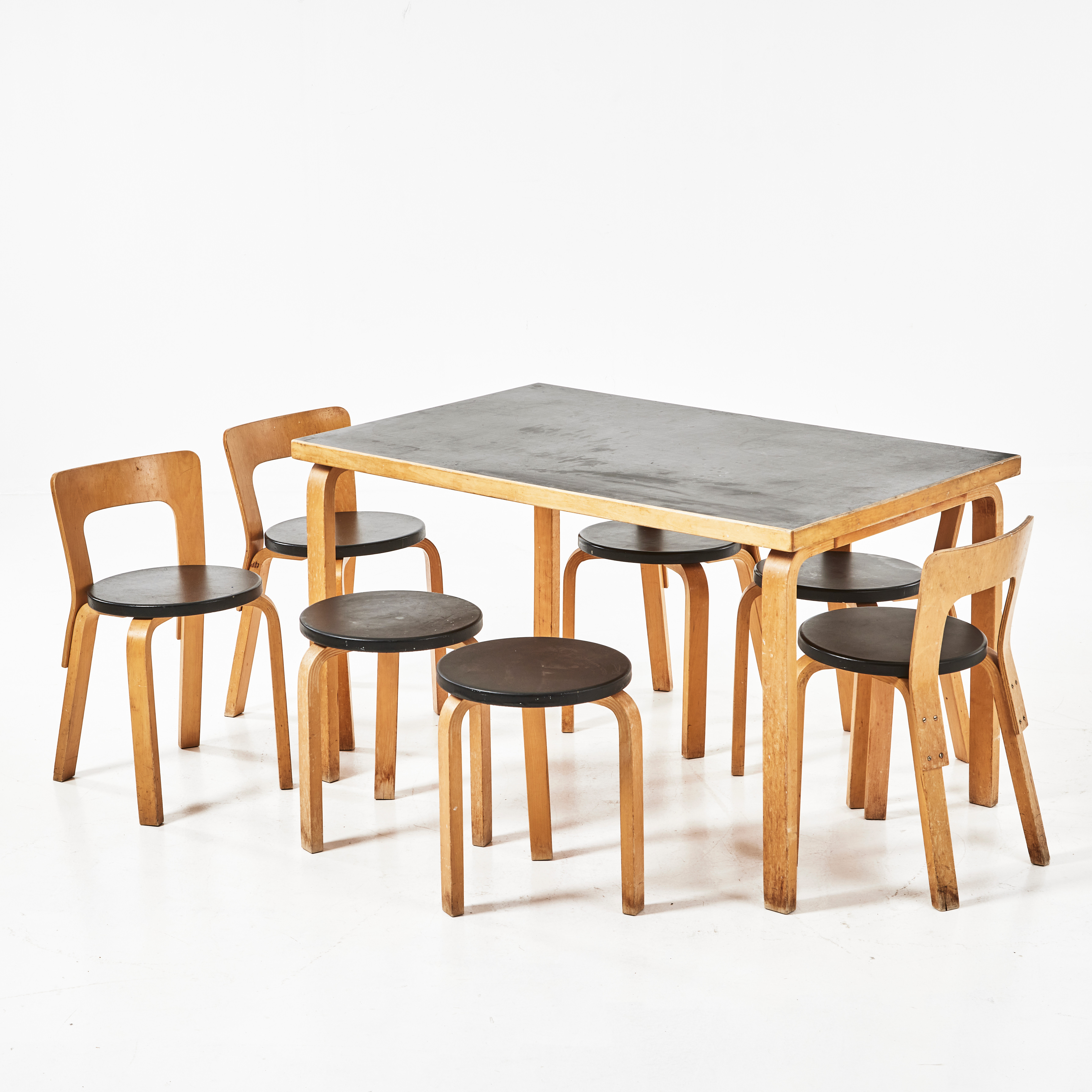 ALVAR AALTO. Stolar med rygg, 5 stycken, pallar, 2 stycken, samt ett matbord, Artek, Finland 1900-talets andra hälft, bord med svartlaminerad skiva, stolar och pallar med sitsar klädda i svart konstläder.