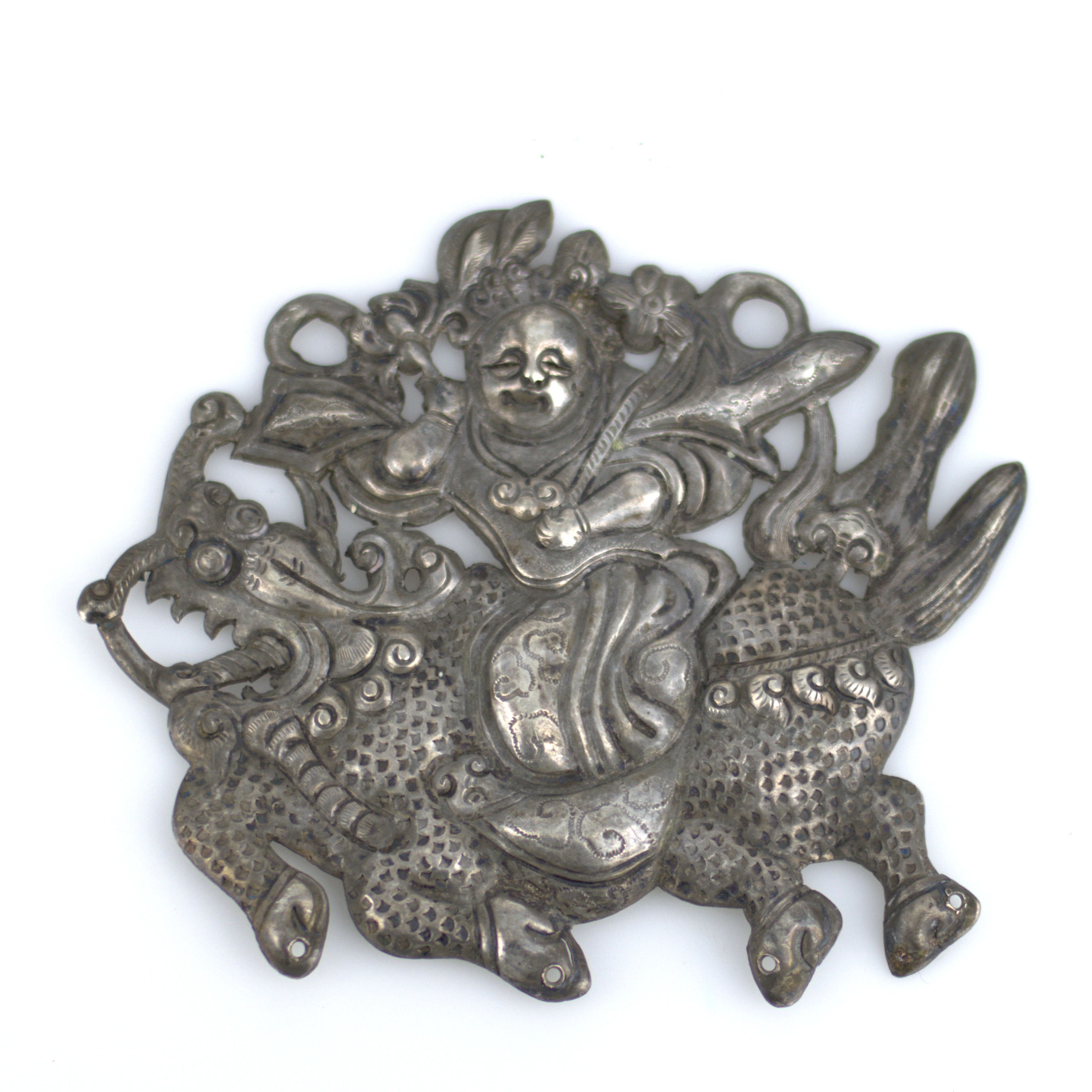 SKYDDSAMULETT, drivet och ciselerat metallarbete, "Qilin Song Zi", pojke som rider på en Qilin, ett mytomspunnet lyckodjur med drakhuvud och fjälliga hovar, Qing-dynastin (1644 - 1912).