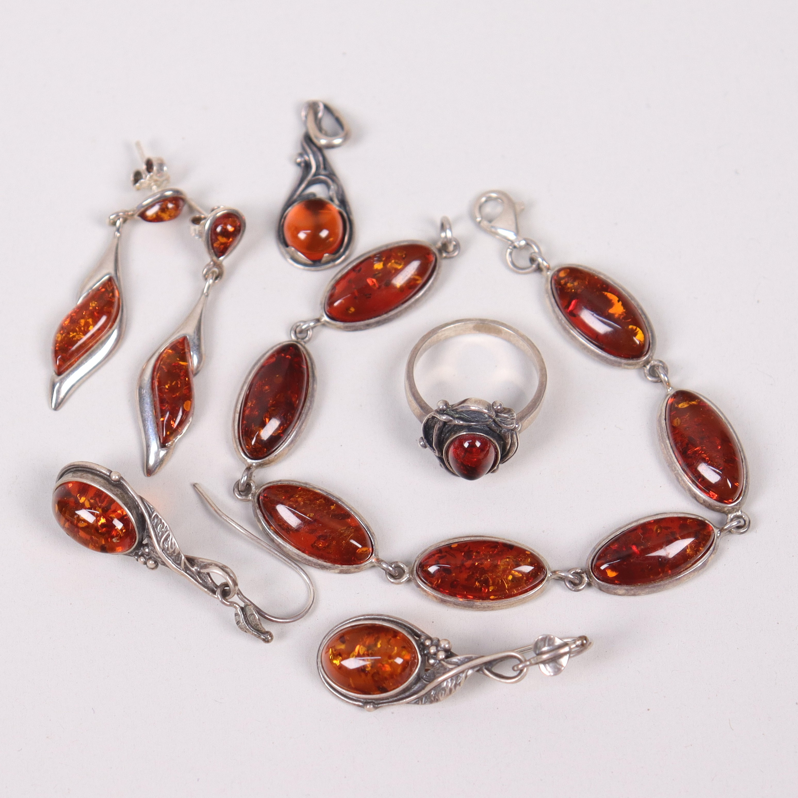 GARNITYR, silver med bärnsten, armband, hänge, ring och örhängen, 7 delar.