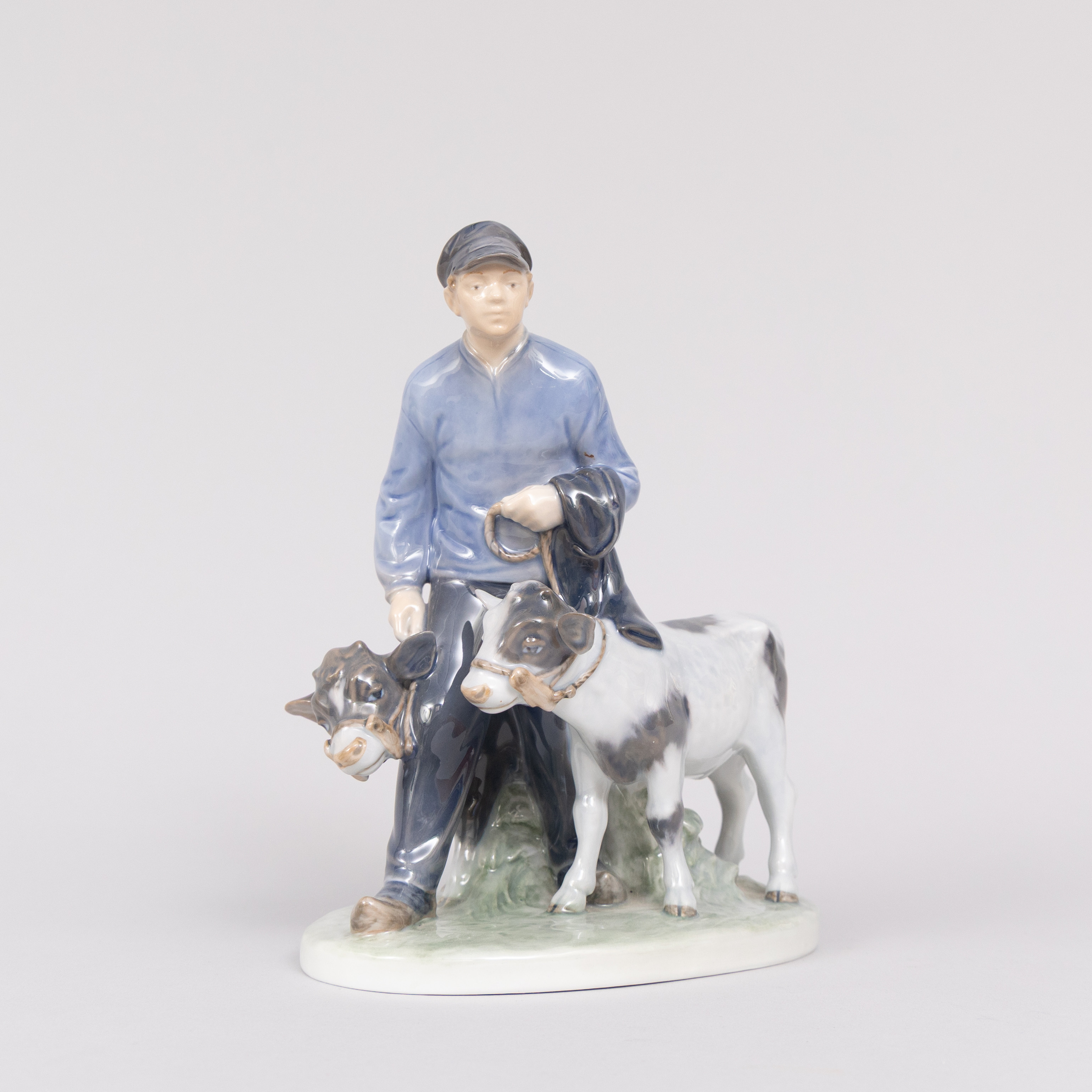 CHRISTIAN THOMSEN (DANMARK 1860-1921). Figurin, Pojke med kalvar, porslin, Royal Copenhagen, Denmark.