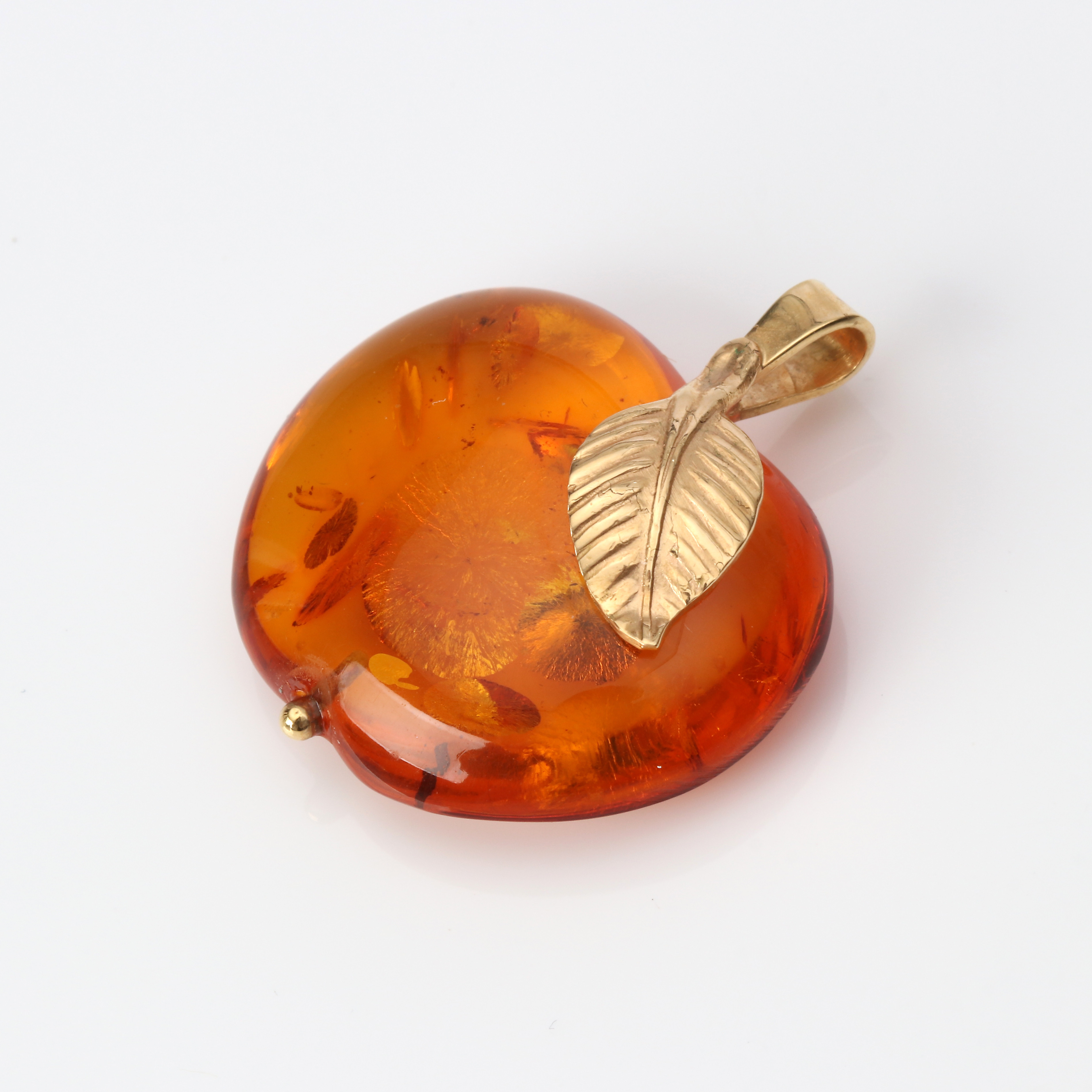 HÄNGE. Bärnsten, i form av ett äpple, detaljer i 18k guld, totalvikt ca 4,7 gram.