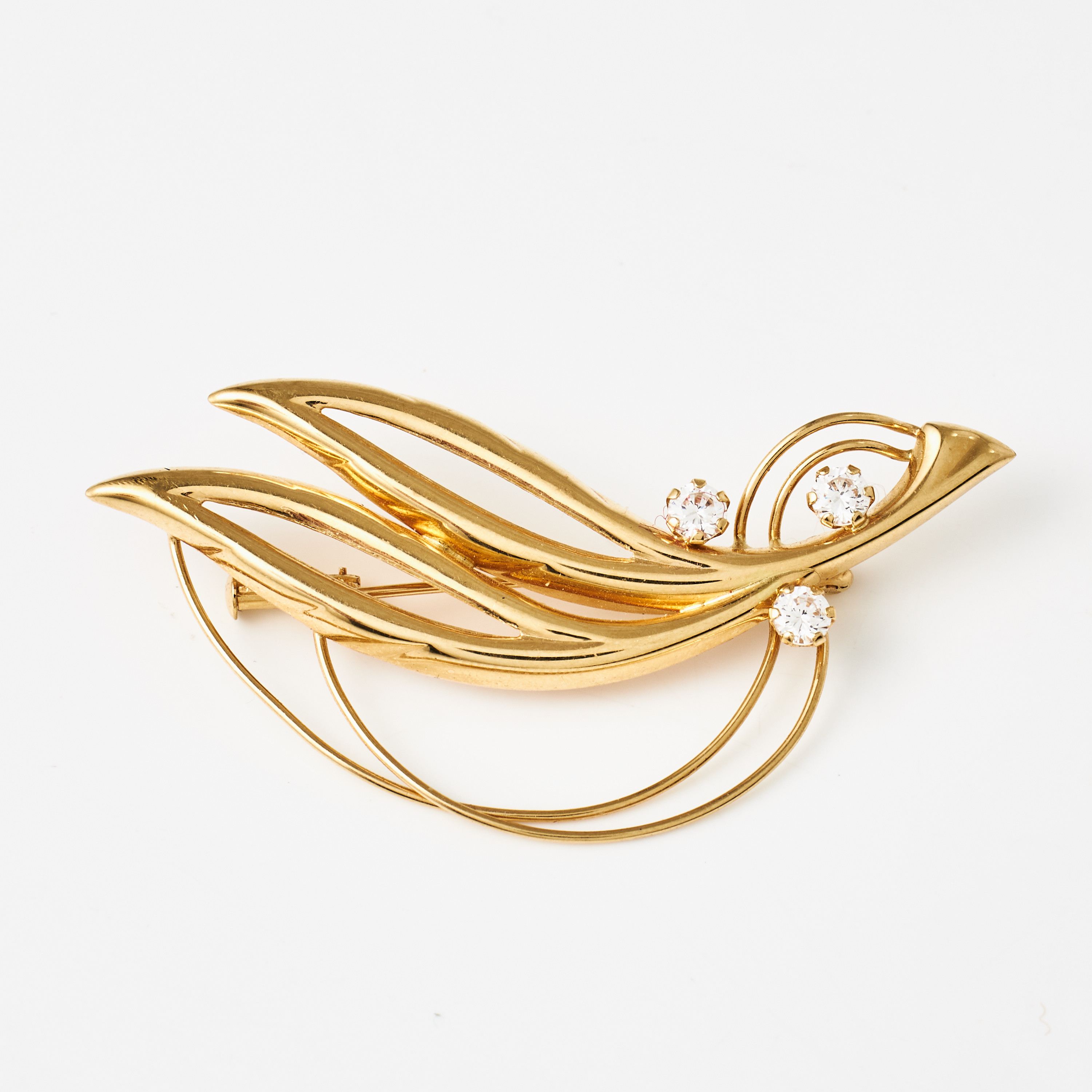 BROSCH, 18 k guld, i form av stiliserad kvist, dekor med 3 fasettslipade vita stenar.