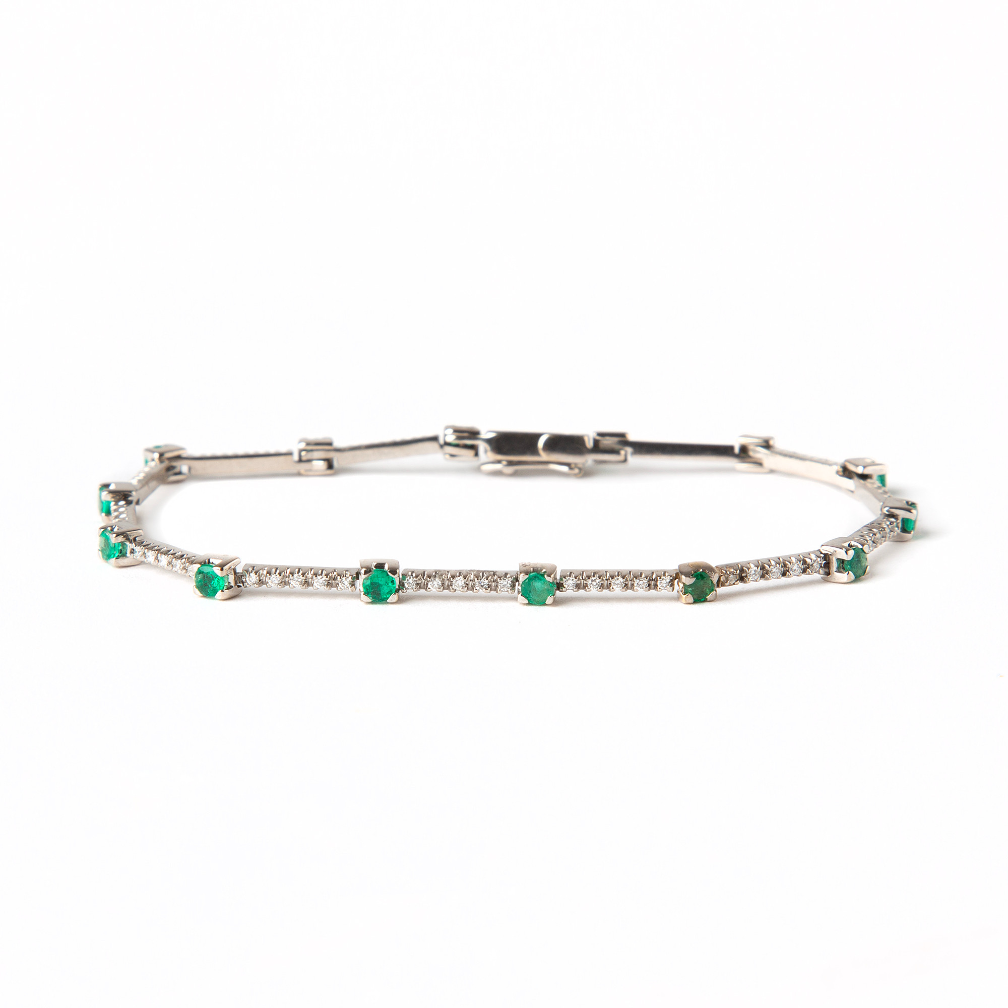 ARMBAND, 18K vitguld med briljantslipade diamanter, totalt ca 0.80 ct samt fasettslipade smaragder totalt ca 1.20 ct.