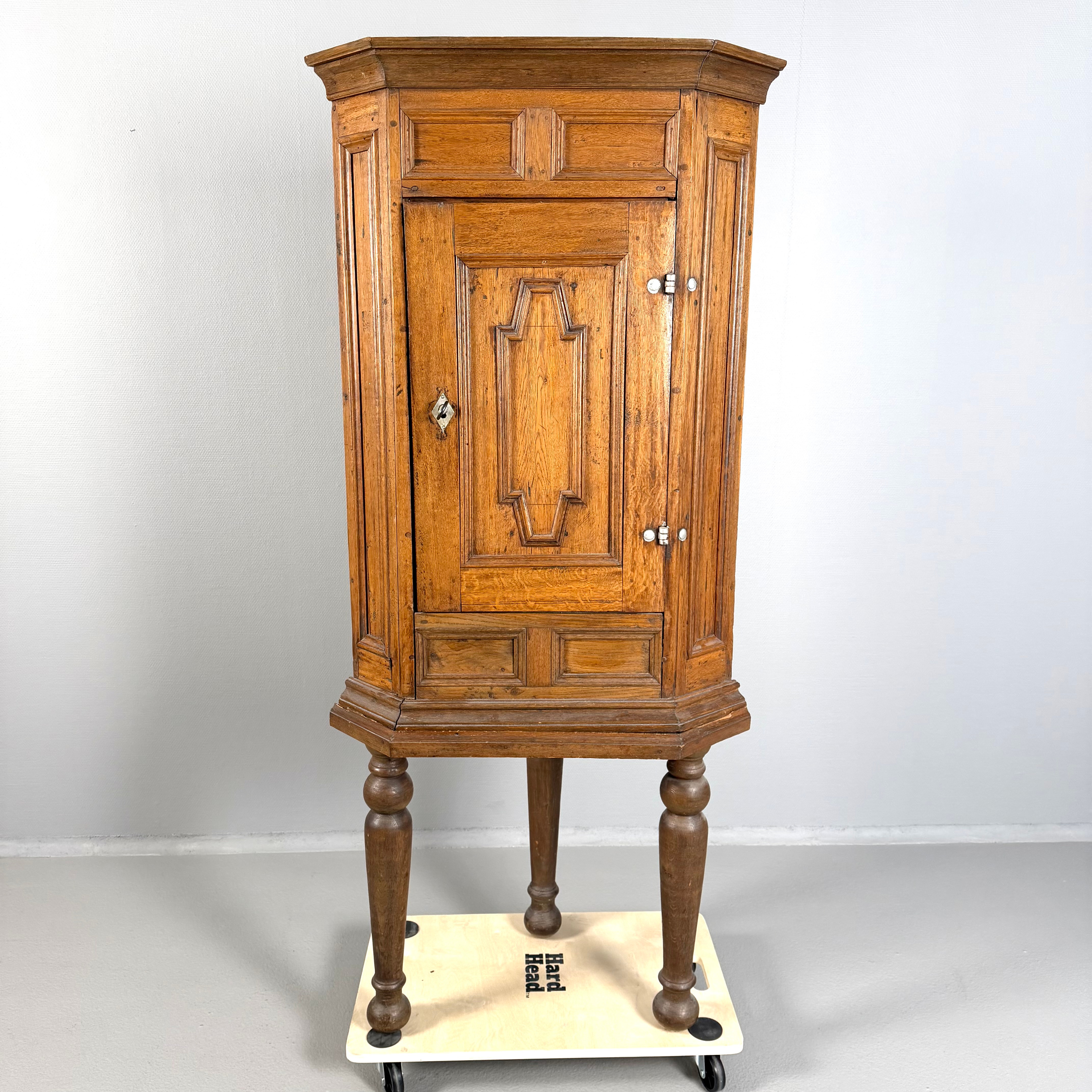 HÖRNSKÅP, 1700-tal, ek, 2-delat, dörrblad med profilerade dekorlister, originallås, invändigt med hyllplan, på benställning med svarvade balusterformade ben.