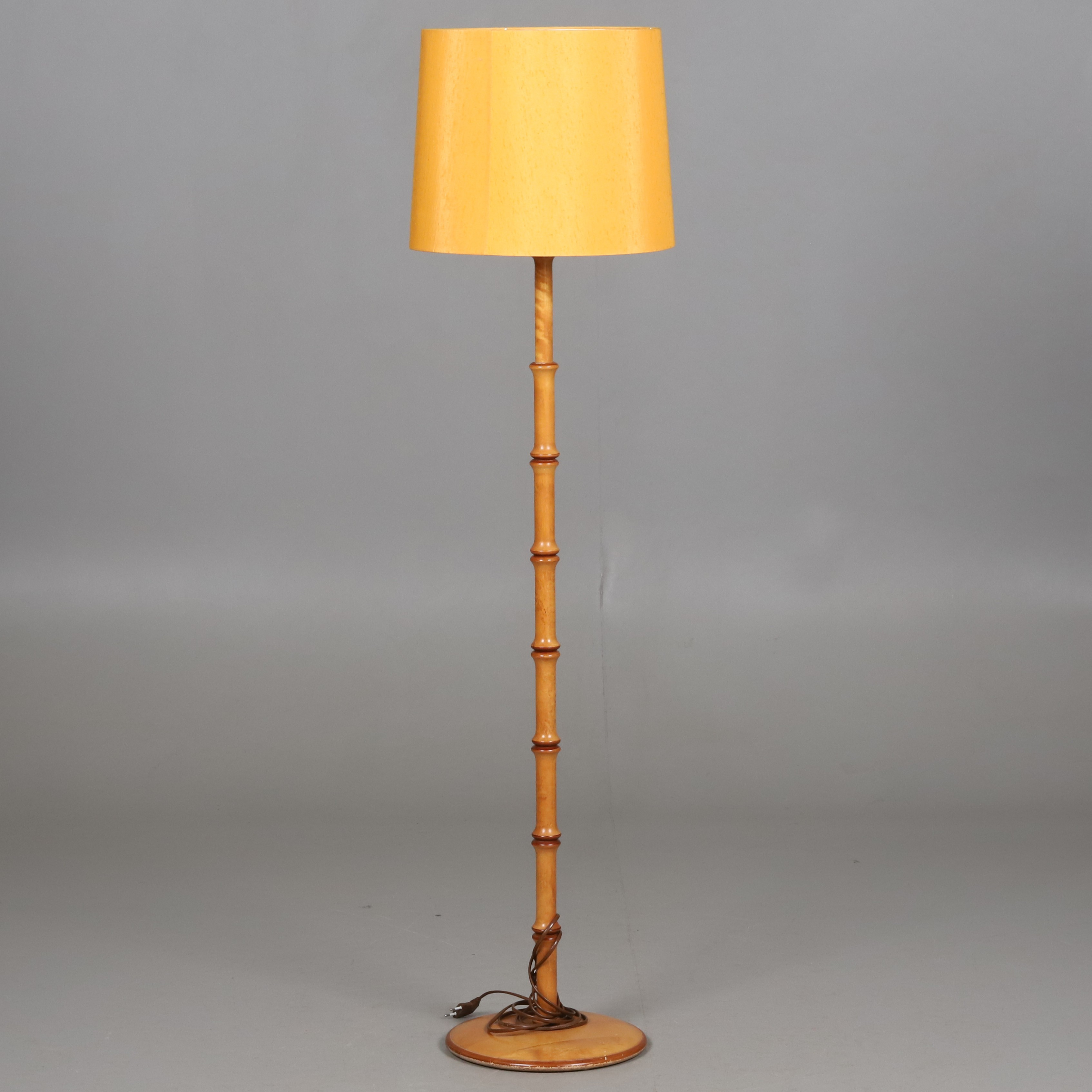 GOLVLAMPA. Svarvad trästomme med gul tygskärm, Aneta, 1900-talets slut.