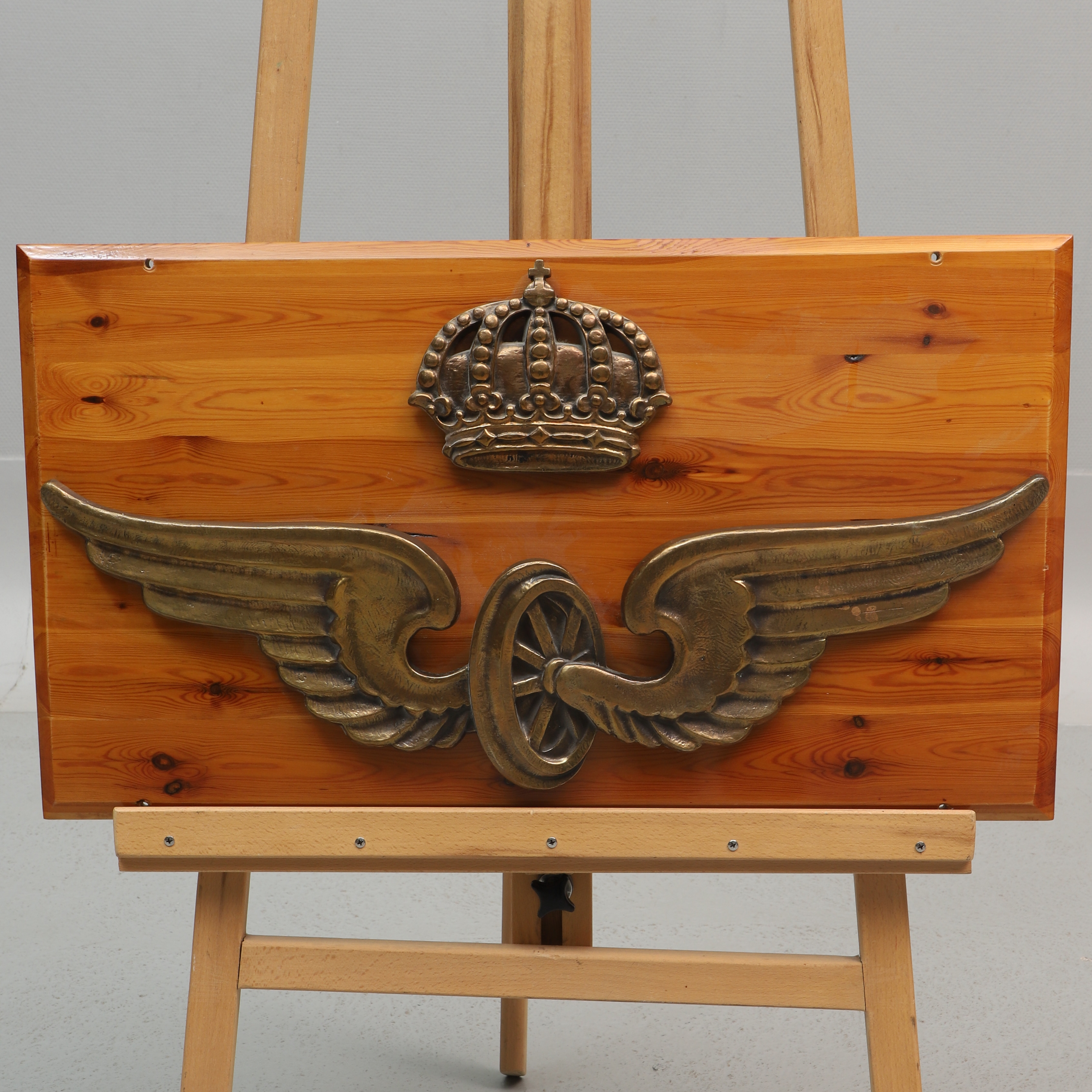 SKYLT med emblem på träplatta, metall och trä, "Bevingade hjulet", Statens Järnvägar, 1900-tal.