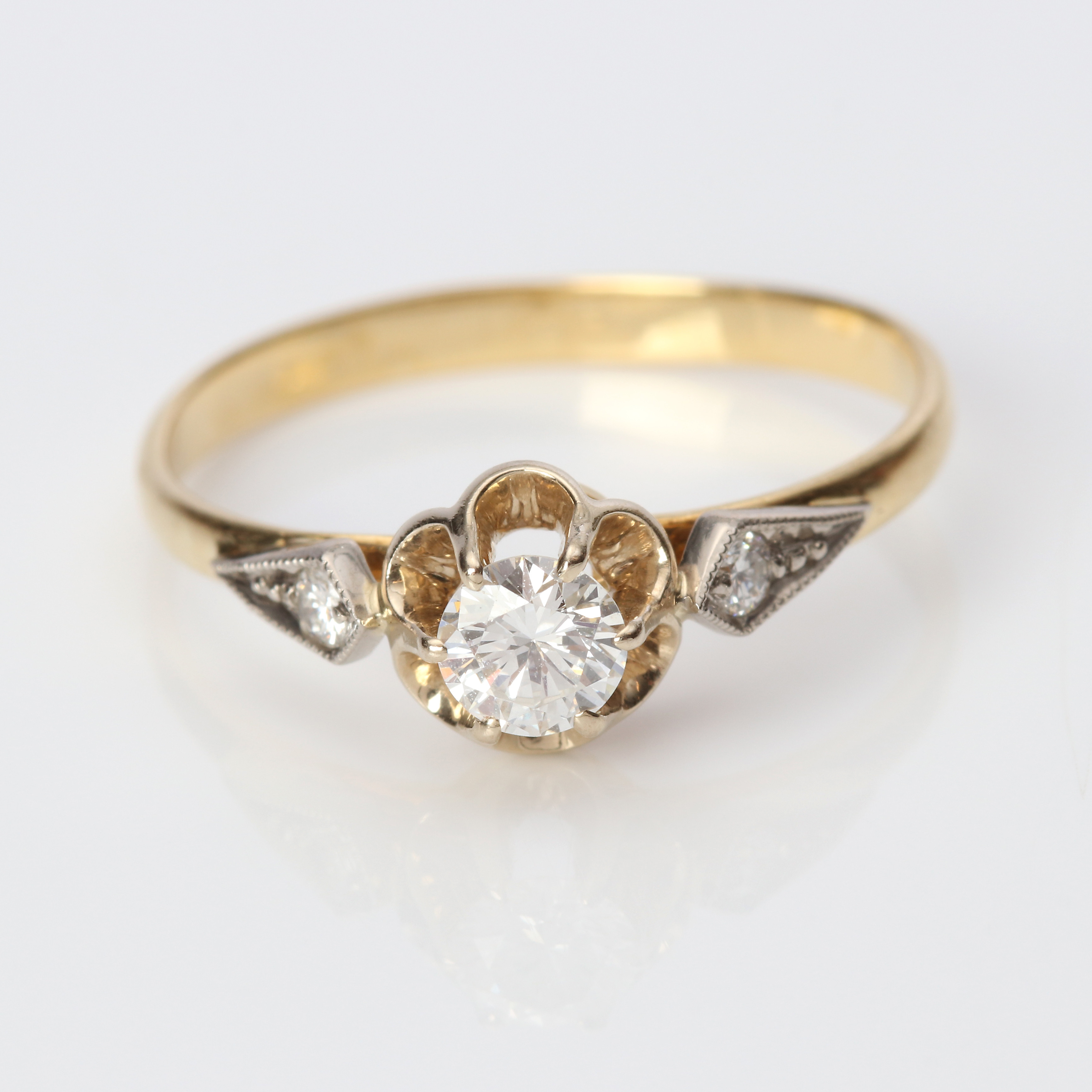 DIAMANTRING. 18k röd- och vitguld med en större brijlantslipad diamant och två mindre briljanter, totalvikt ca 2,7 gram.