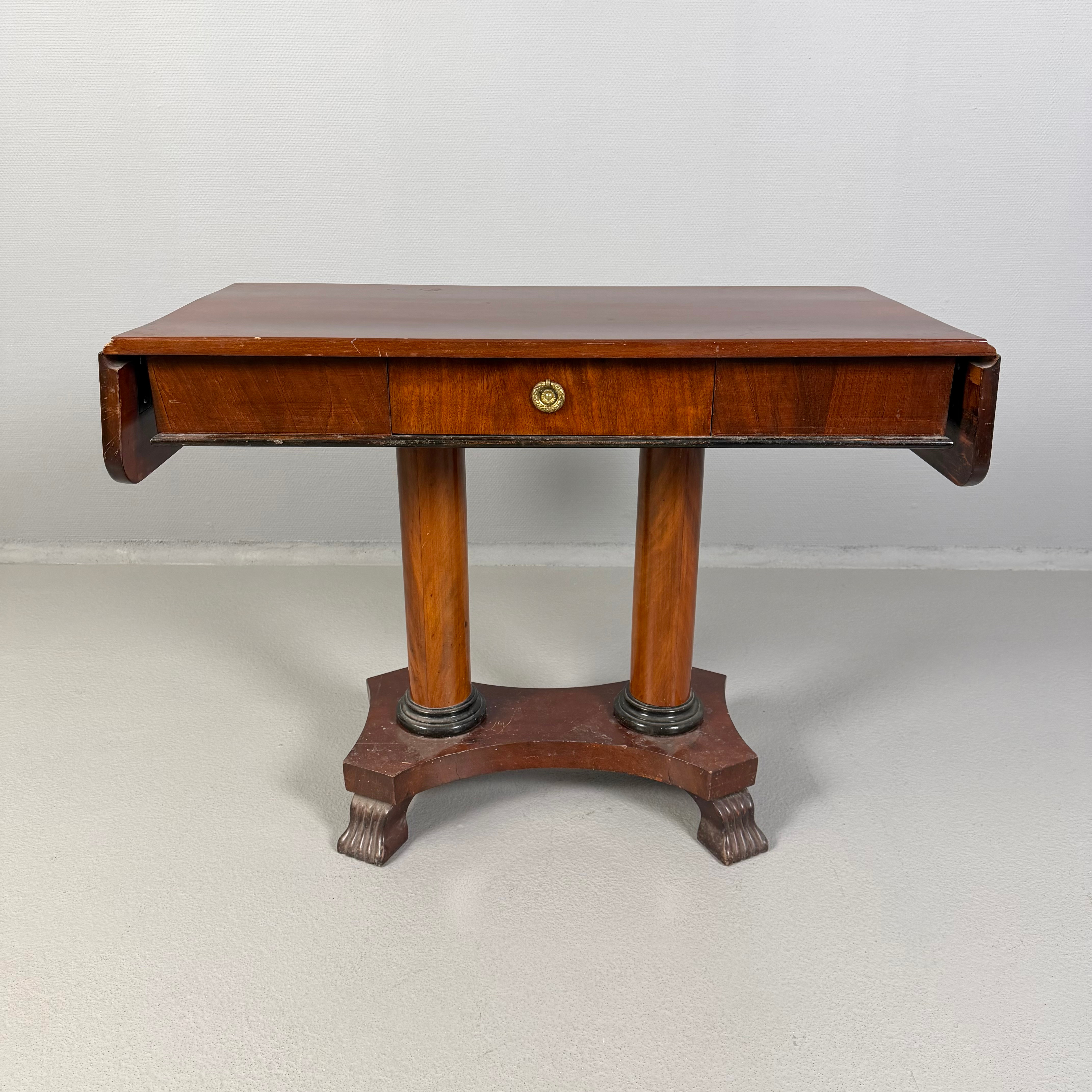 KLAFFBORD, 1900-talets första hälft, karl-johan-stil, faner i mahogny, sarg med låda, 2 uppfällbara klaffar, benställning på pelare i par, konturerad for med stiliserade tassfötter, förgyllt dragbeslag i form av lagerkrans.