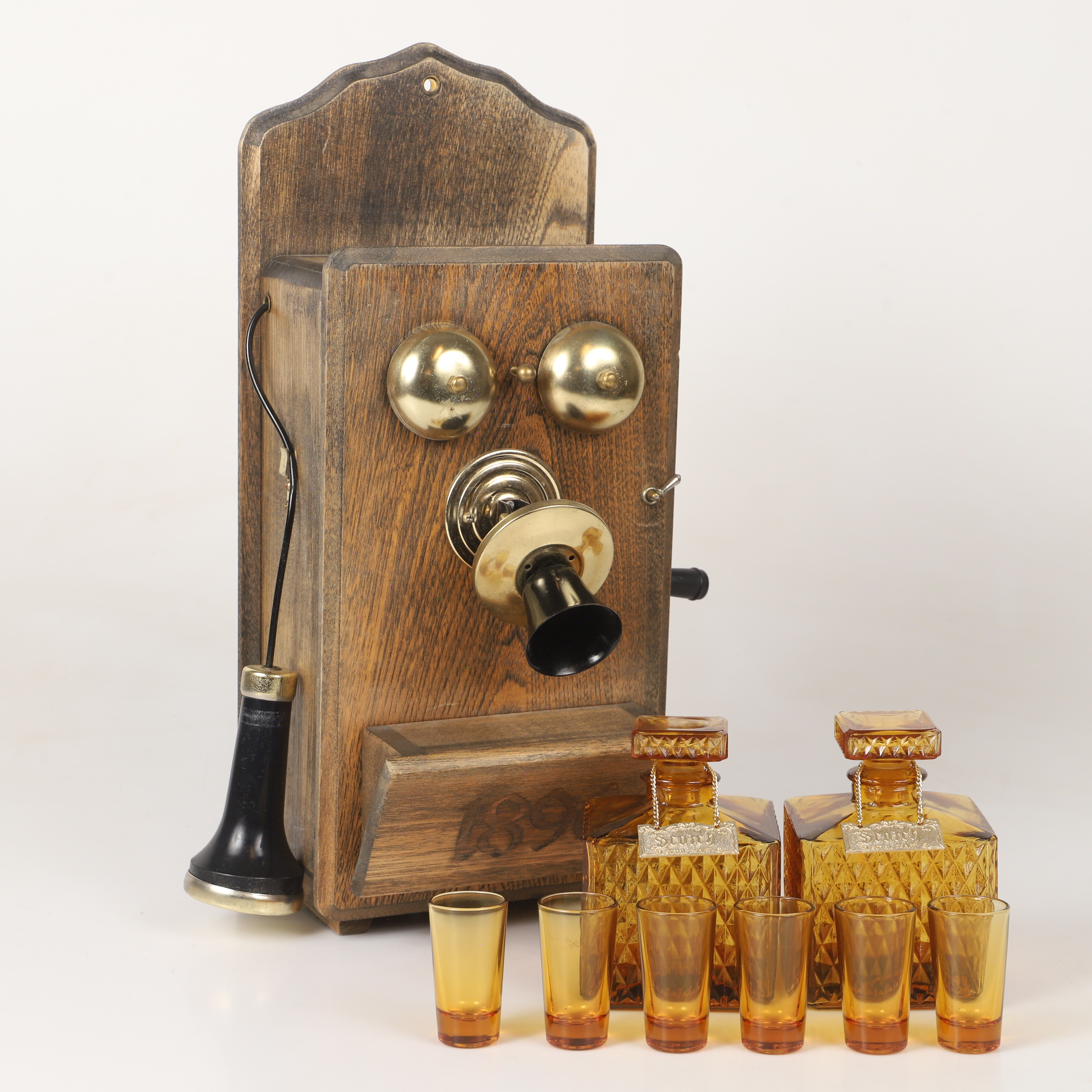 BARSKÅP, trä och metall i form av väggtelefon, 1900-tal.