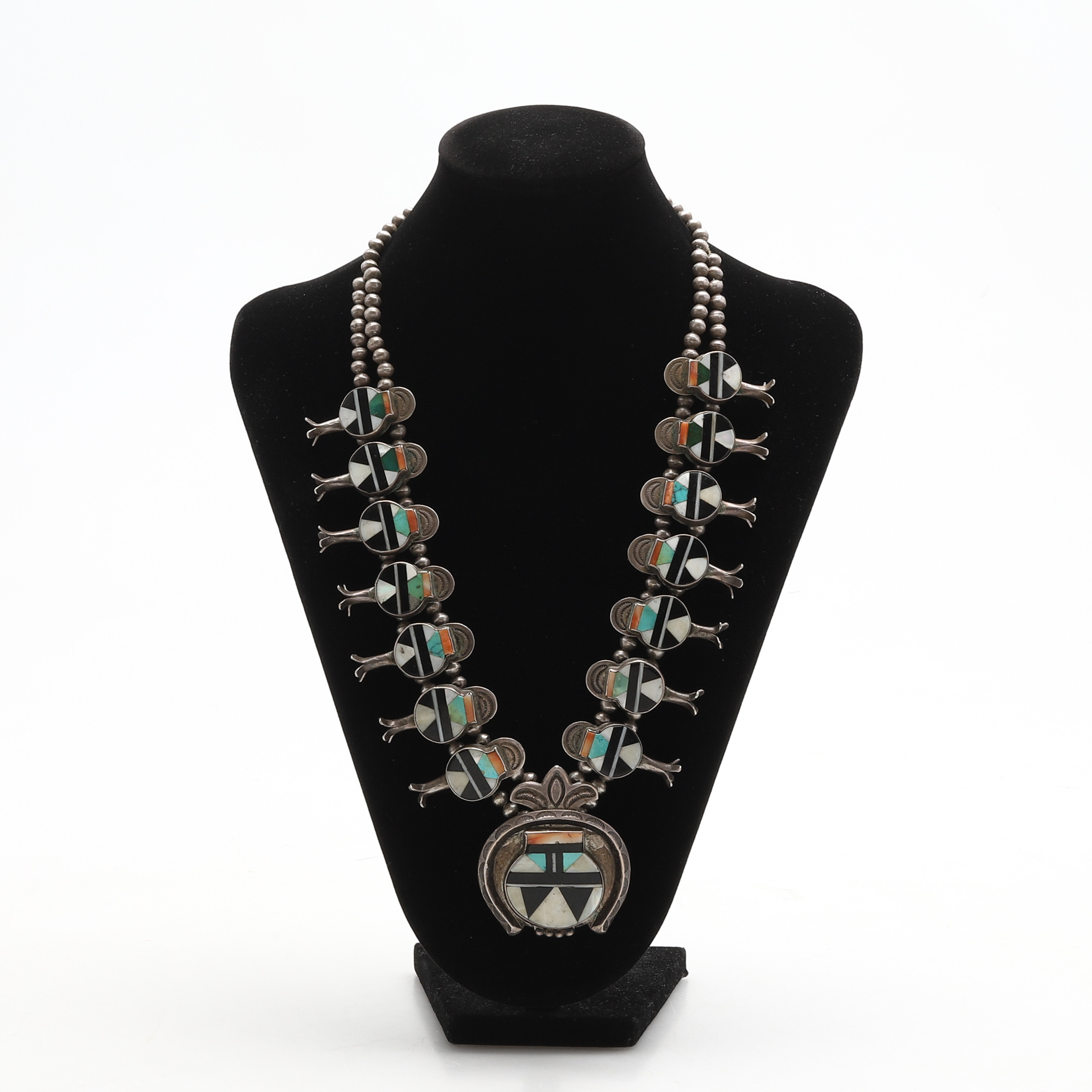 HALSBAND, "Native American Squash Blossom Necklace", silver, dekor med olika stenar avslut med hänge s.k. Naja (med betydelse halvmåneform), Zuni Tribe. 1900-talets mitt. Vikt ca 187 gram.
