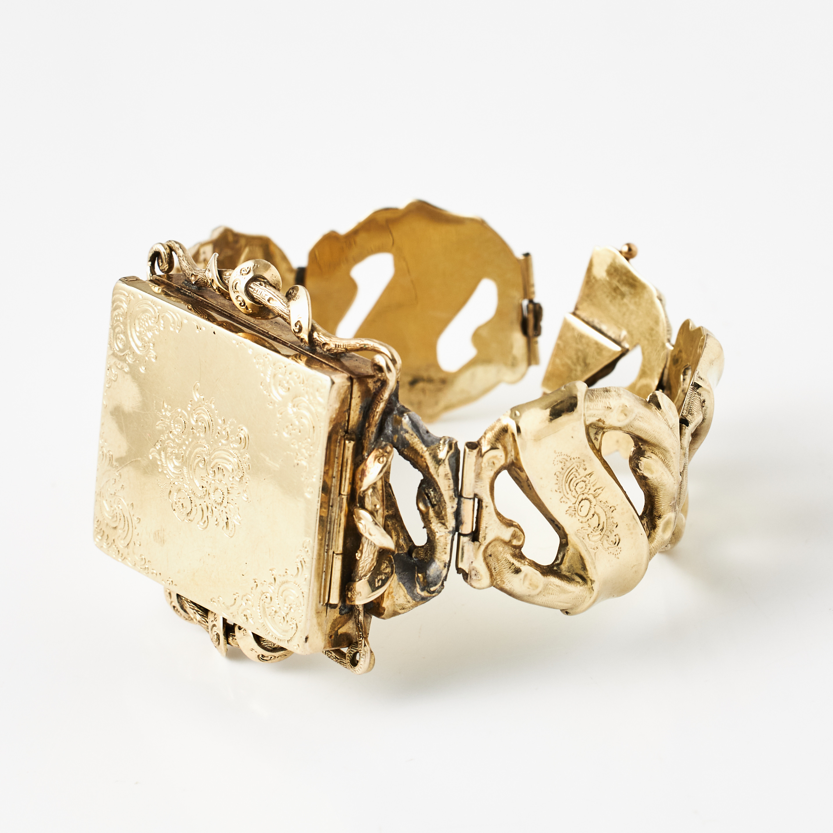 ARMBAND, förgyllt silver, graverad rocailledekor, mittparti med öppningsbar gömma, stämplar saknas, 1850-tal.