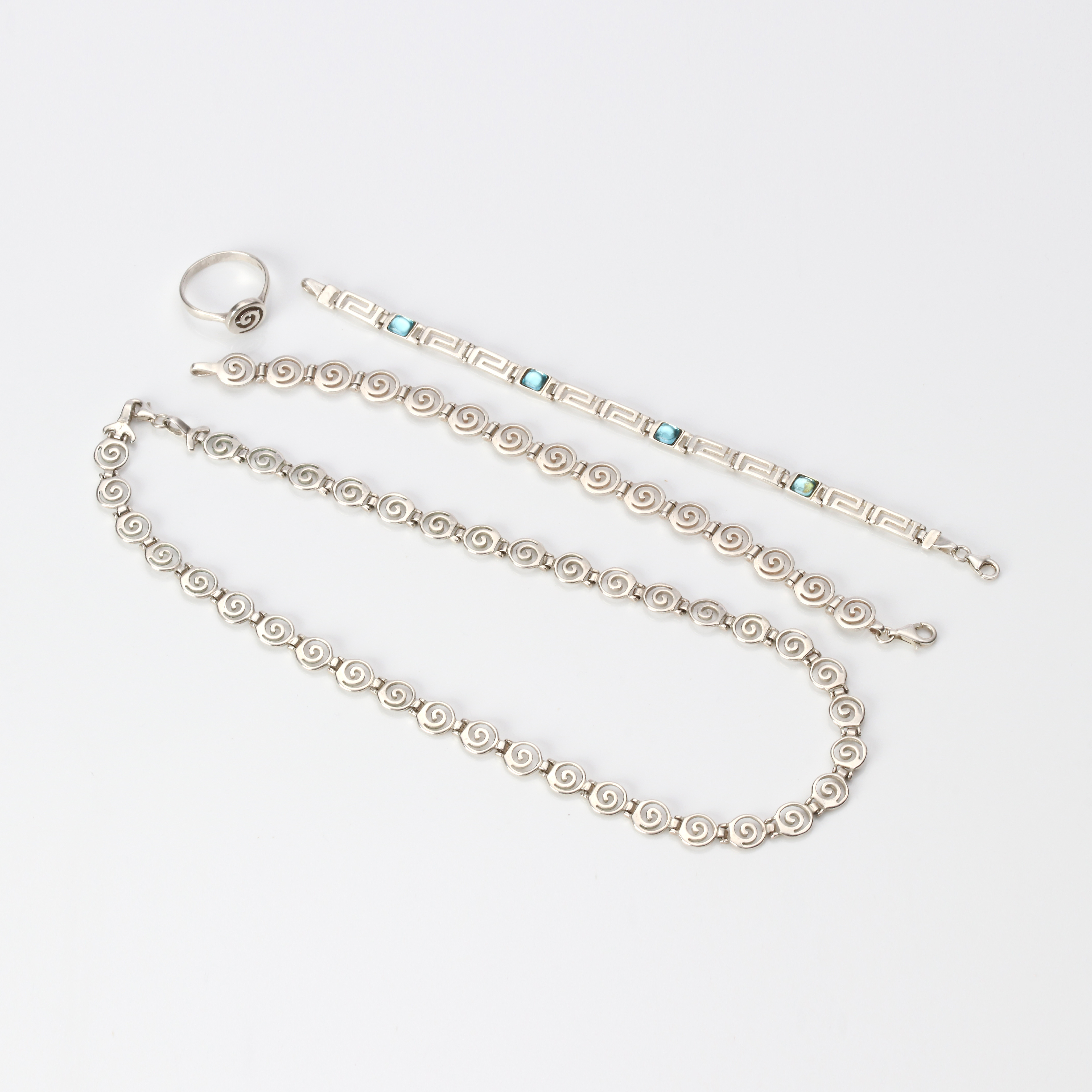 SILVERSMYCKEN, FYRA ST. Sterlingsilver med blå glasstenar, totalvikt ca 43,1 gram.