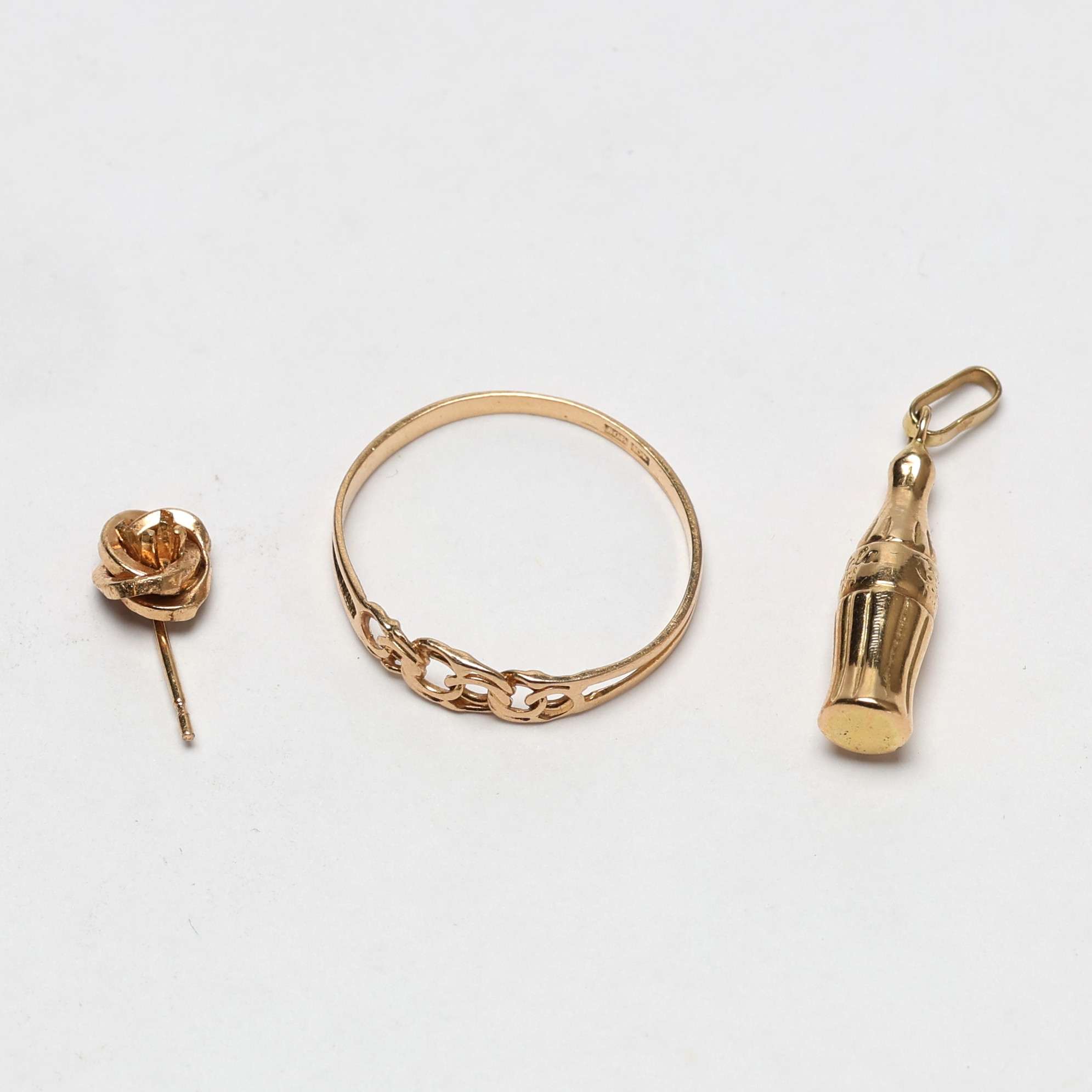 DIVERSE GULDFÖREMÅL. 18k guld, ring, "Coca Cola-hänge", öronhänge, vikt ca 1,94 g.
