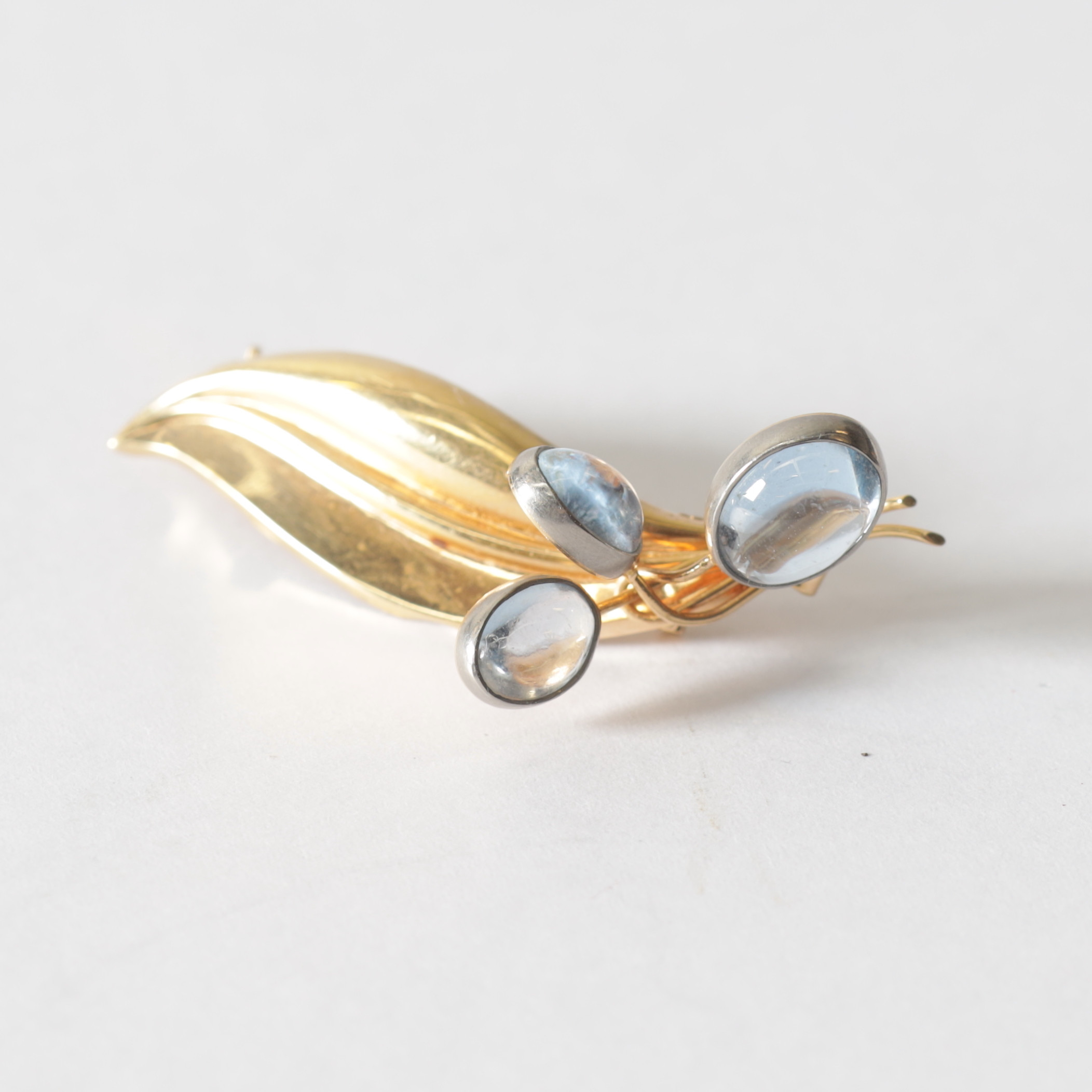 BROSCH, 18K guld med cabuchonslipade månstenar, 1950-tal. Totalvikt ca 4 gram.