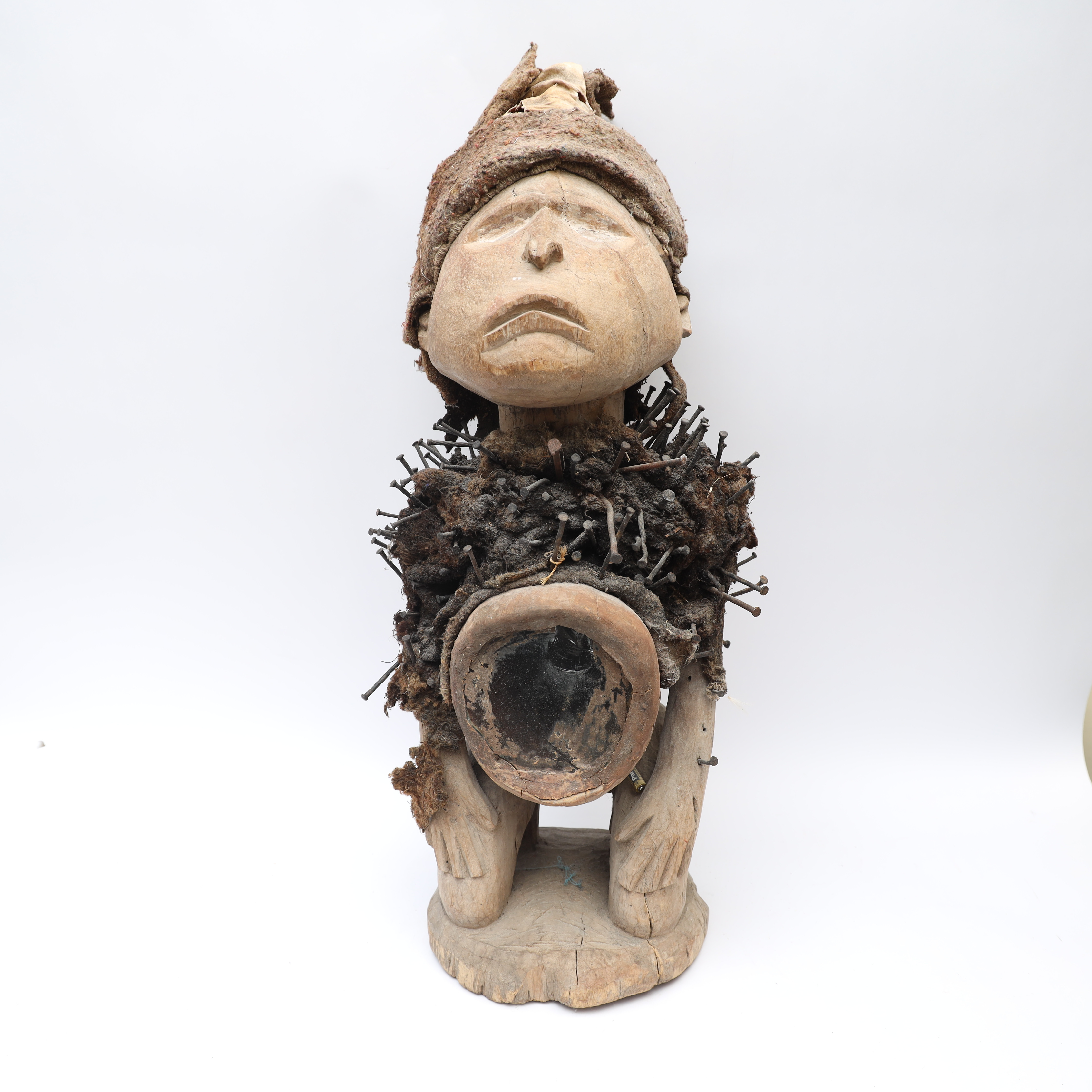 SKULPTUR, troligen Afrika, skulpterat trä, metall och textil, mage med infällt glas.