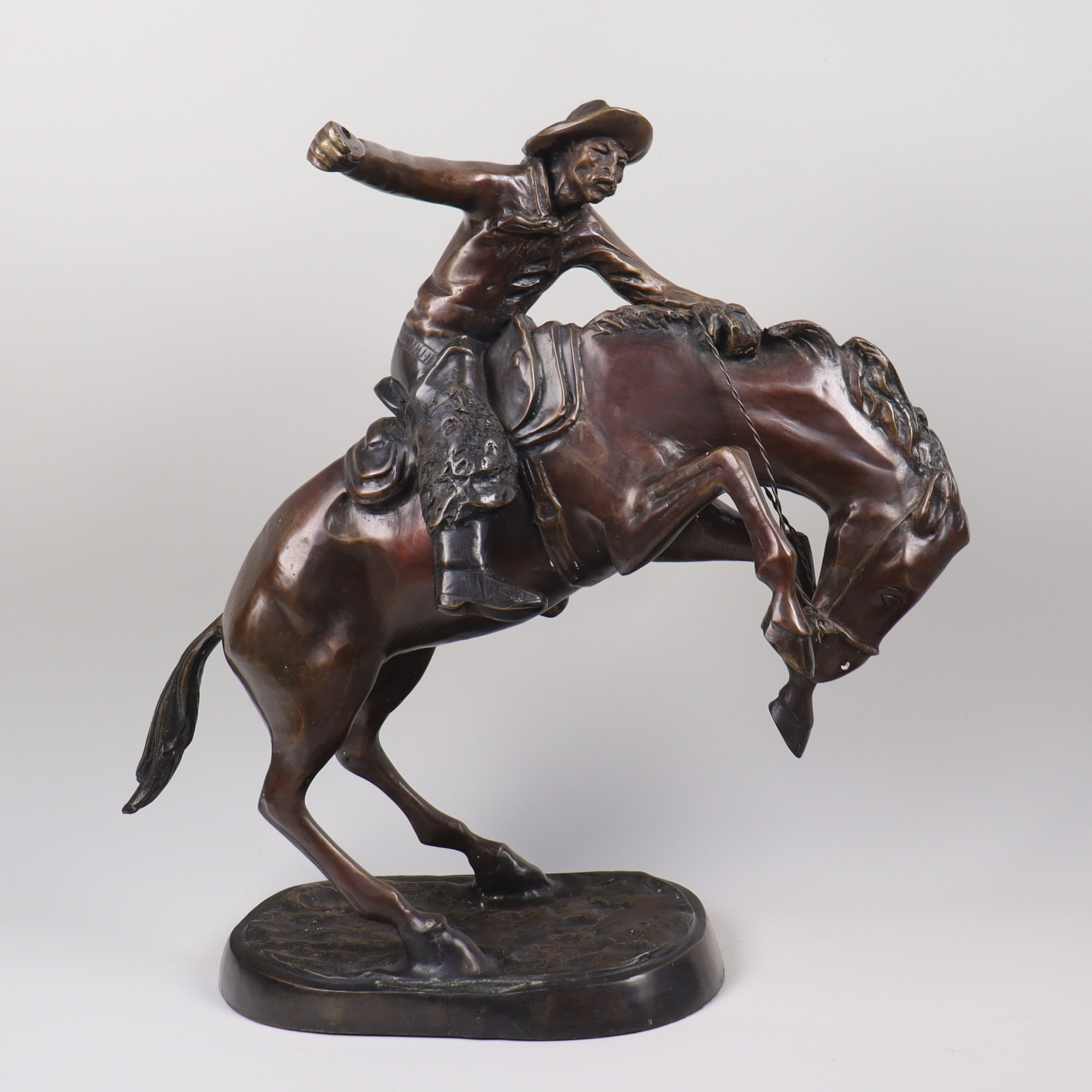 FREDERIC REMINGTON. EFTER. skulptur i brons, ridande cowboy.